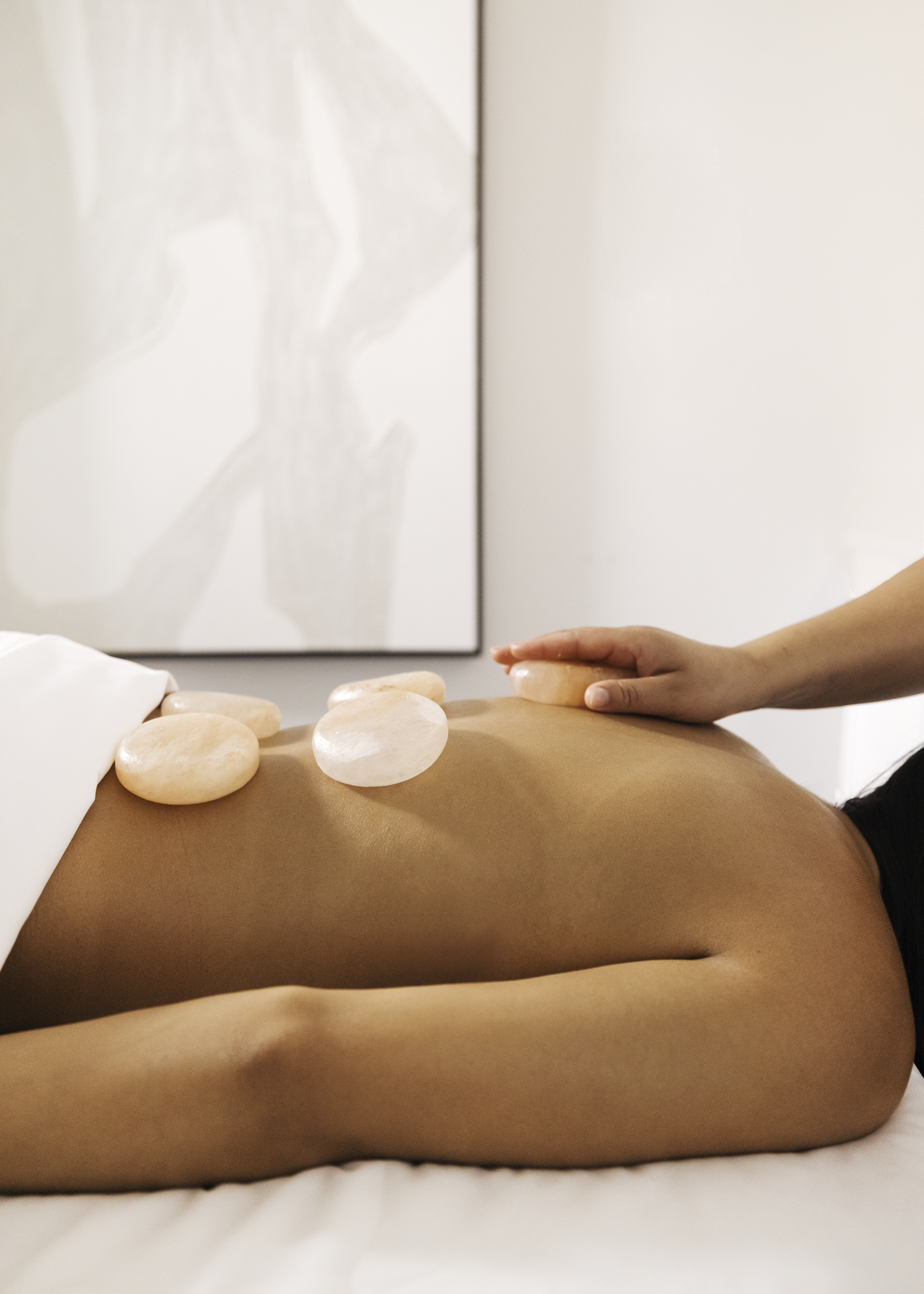Woman receiving Therapeutic Fusion Himalayan Salt Stone Massage at Seawater Spa.