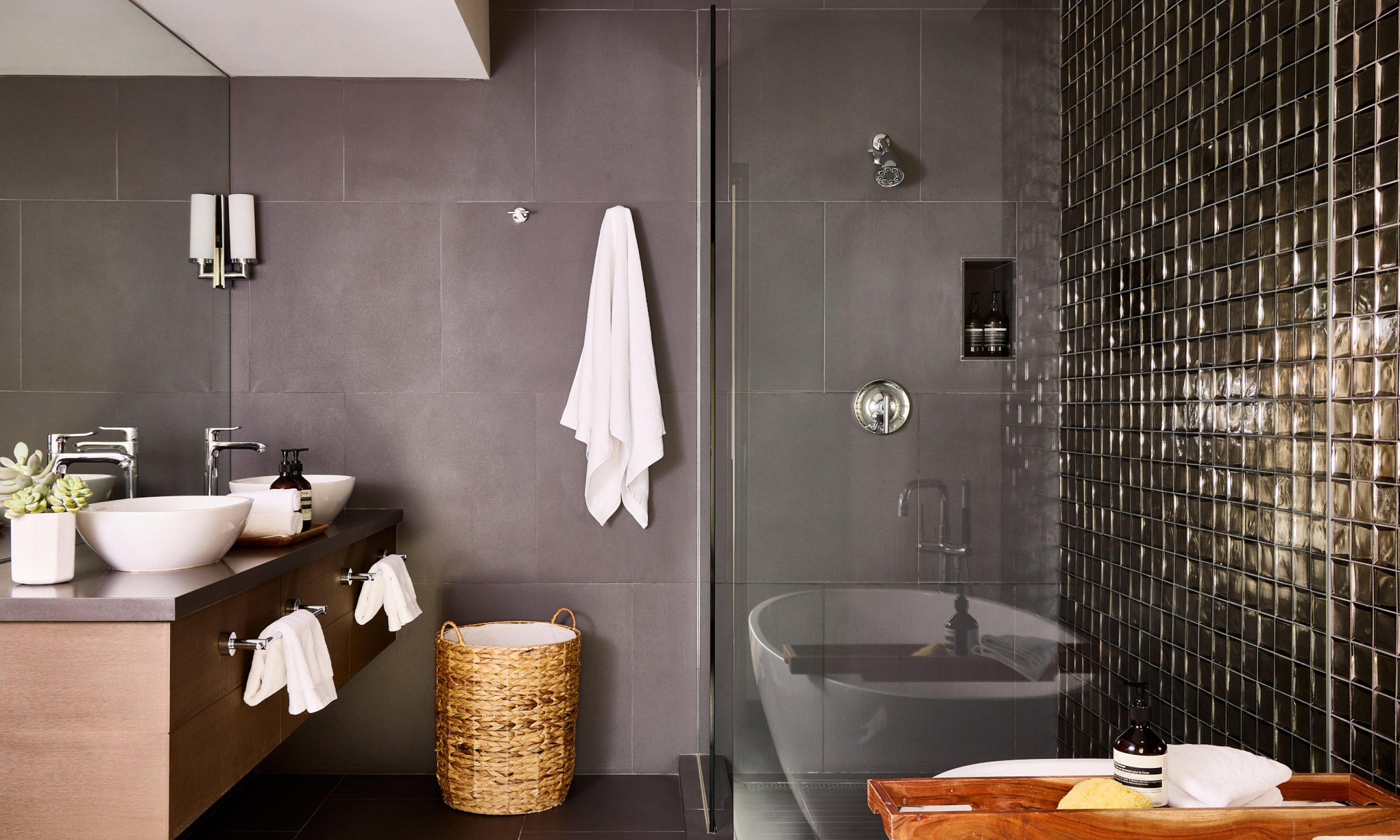 Metallic tiled bathroom with soaking tub, walk-in shower, two sinks and vanity.