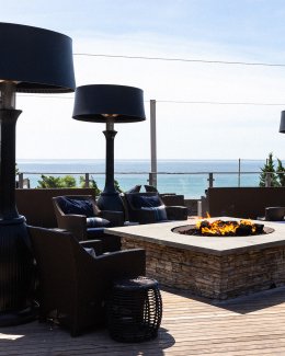 Firepit on patio with seating overlooking the ocean