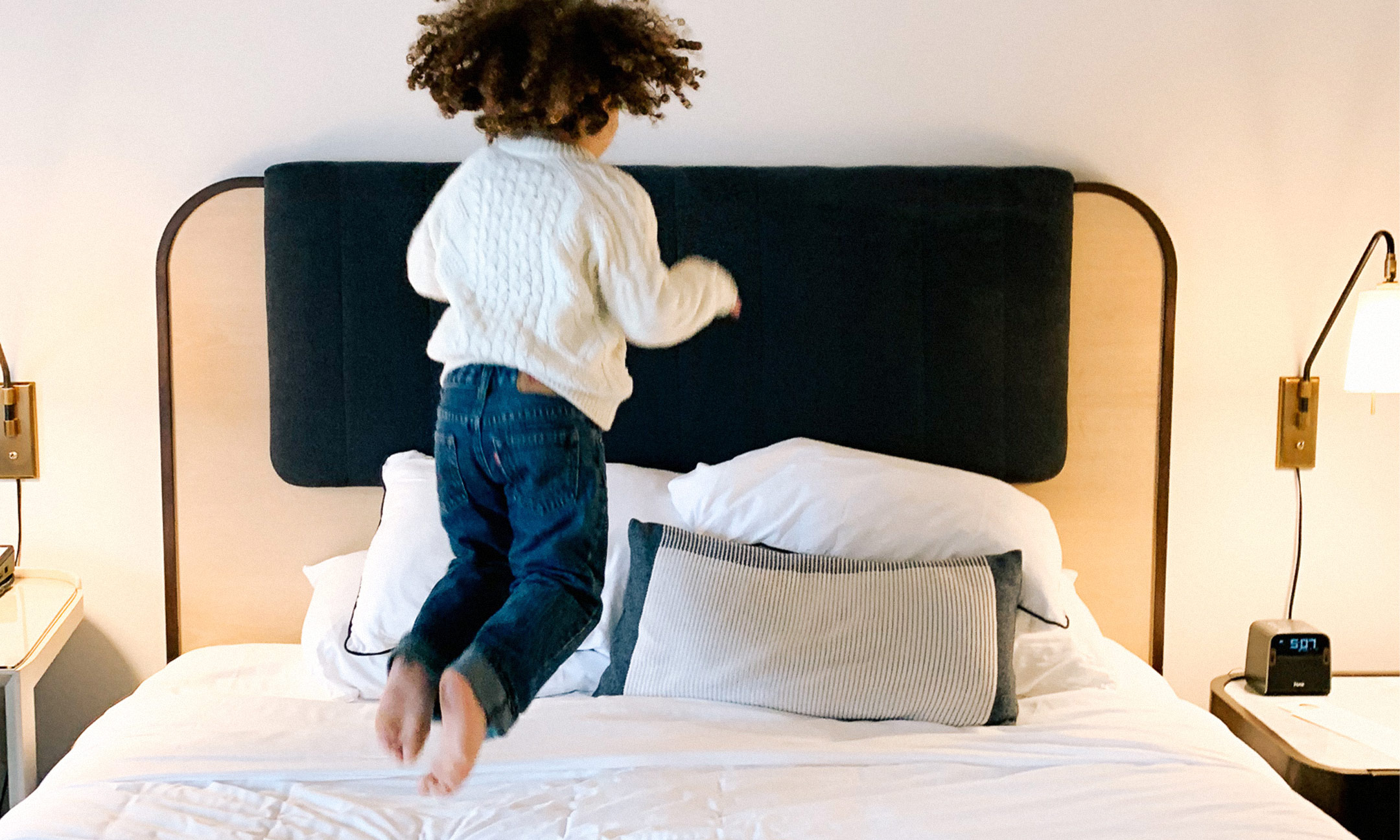 child jumping on bed