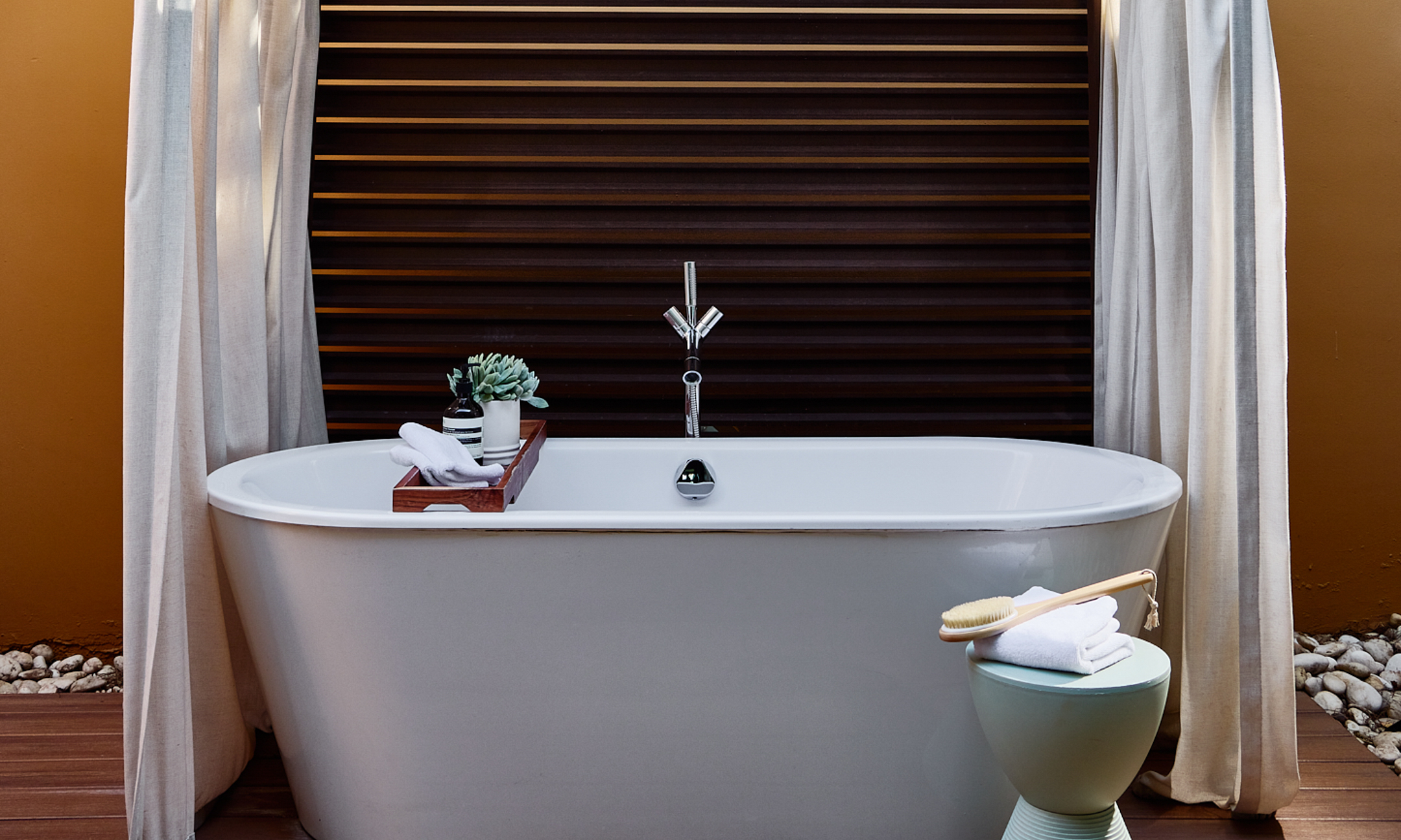 Outdoor soaking tub with towels and toiletries.