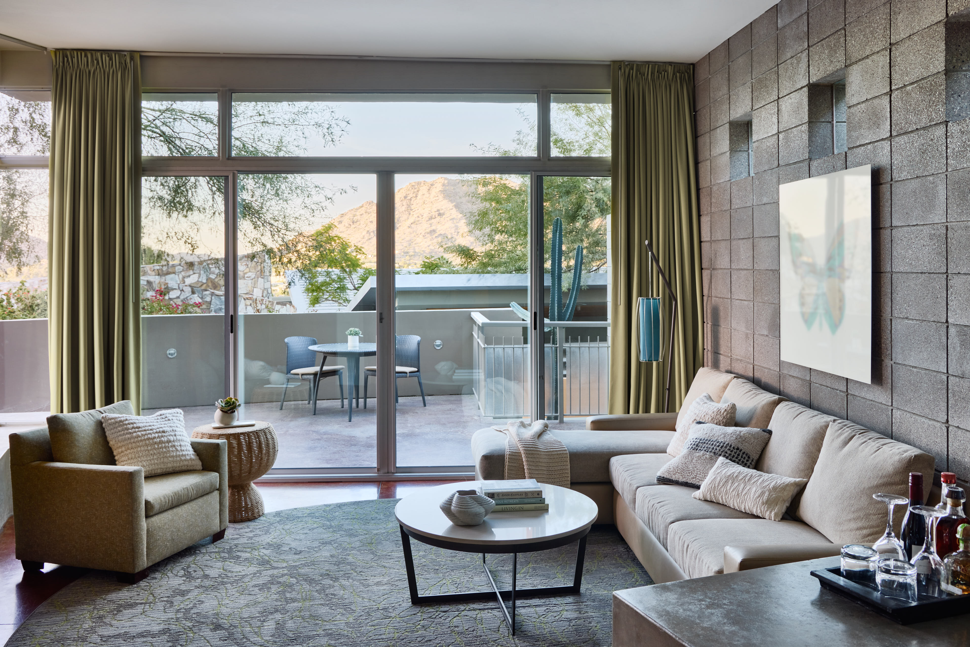 Spa Suite living room with couch and sitting area, floor-to-ceiling windows and outdoor patio.
