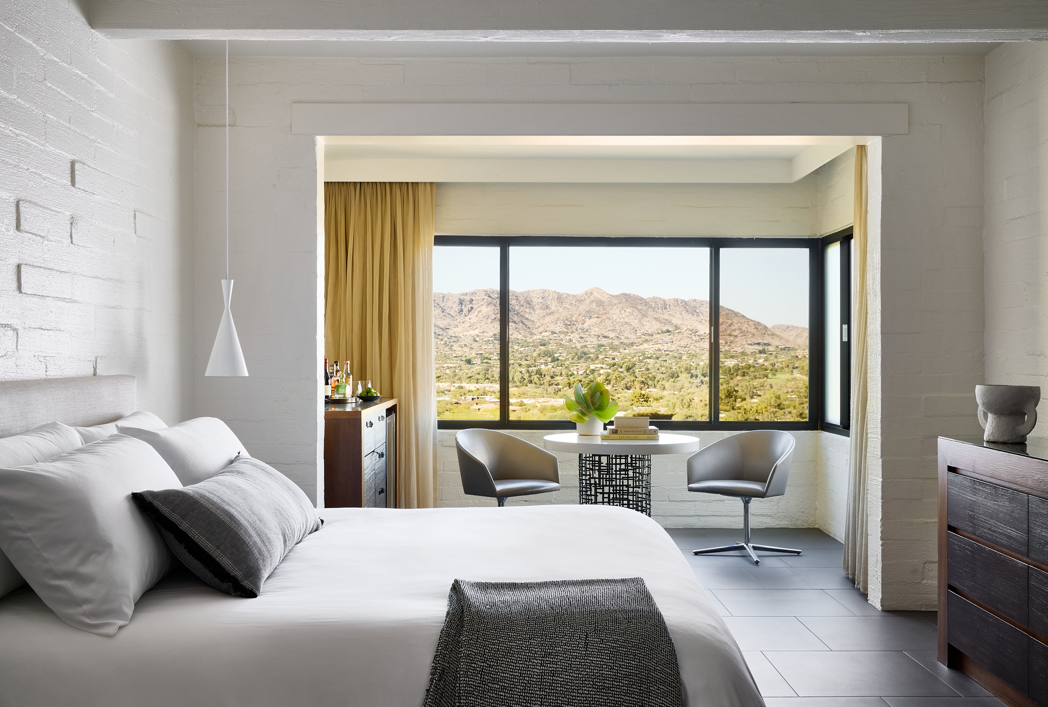 Bedroom with king bed, dresser and sitting area overlooking valley views.