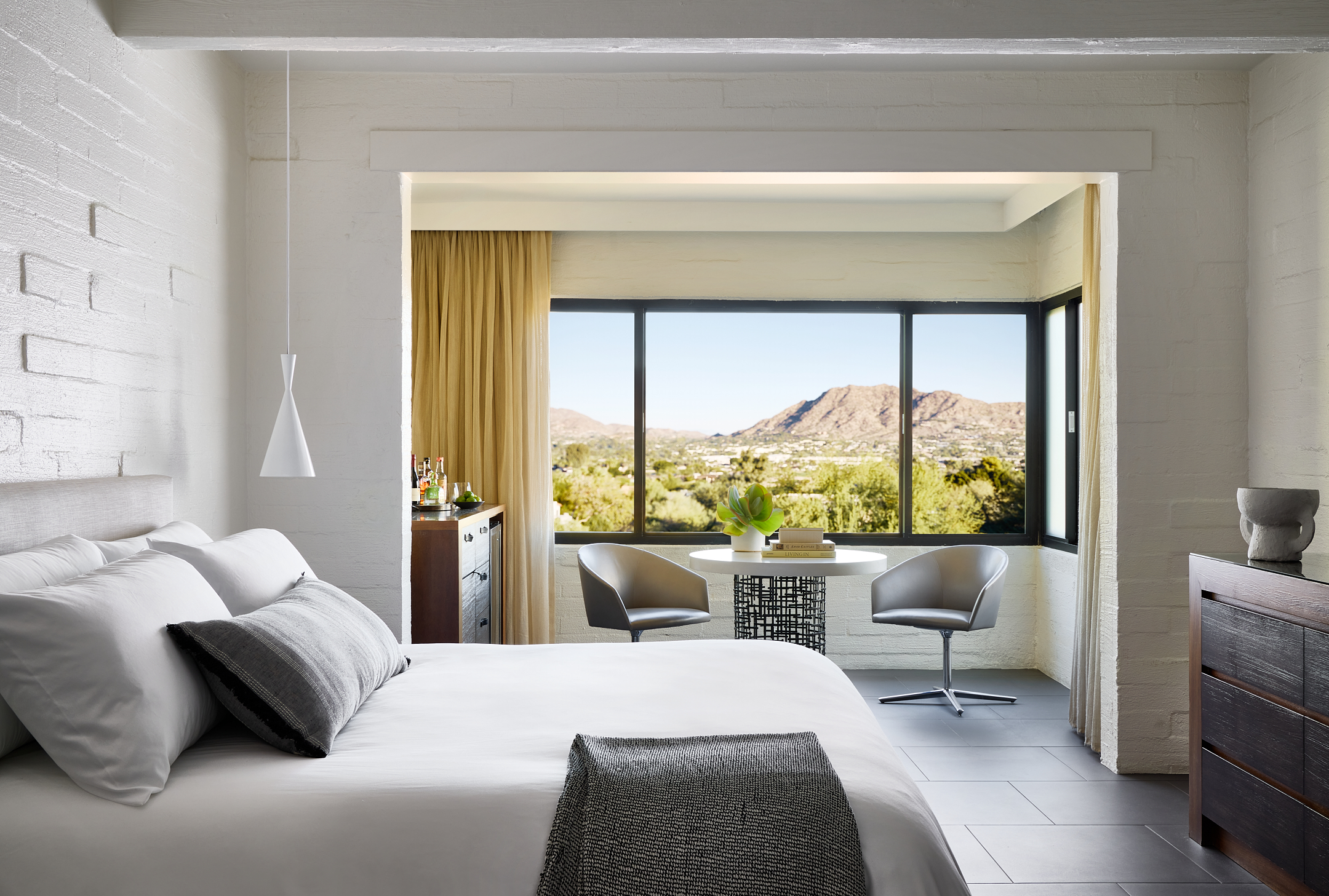 Bedroom with king bed, dresser and seating area overlooking valley views.