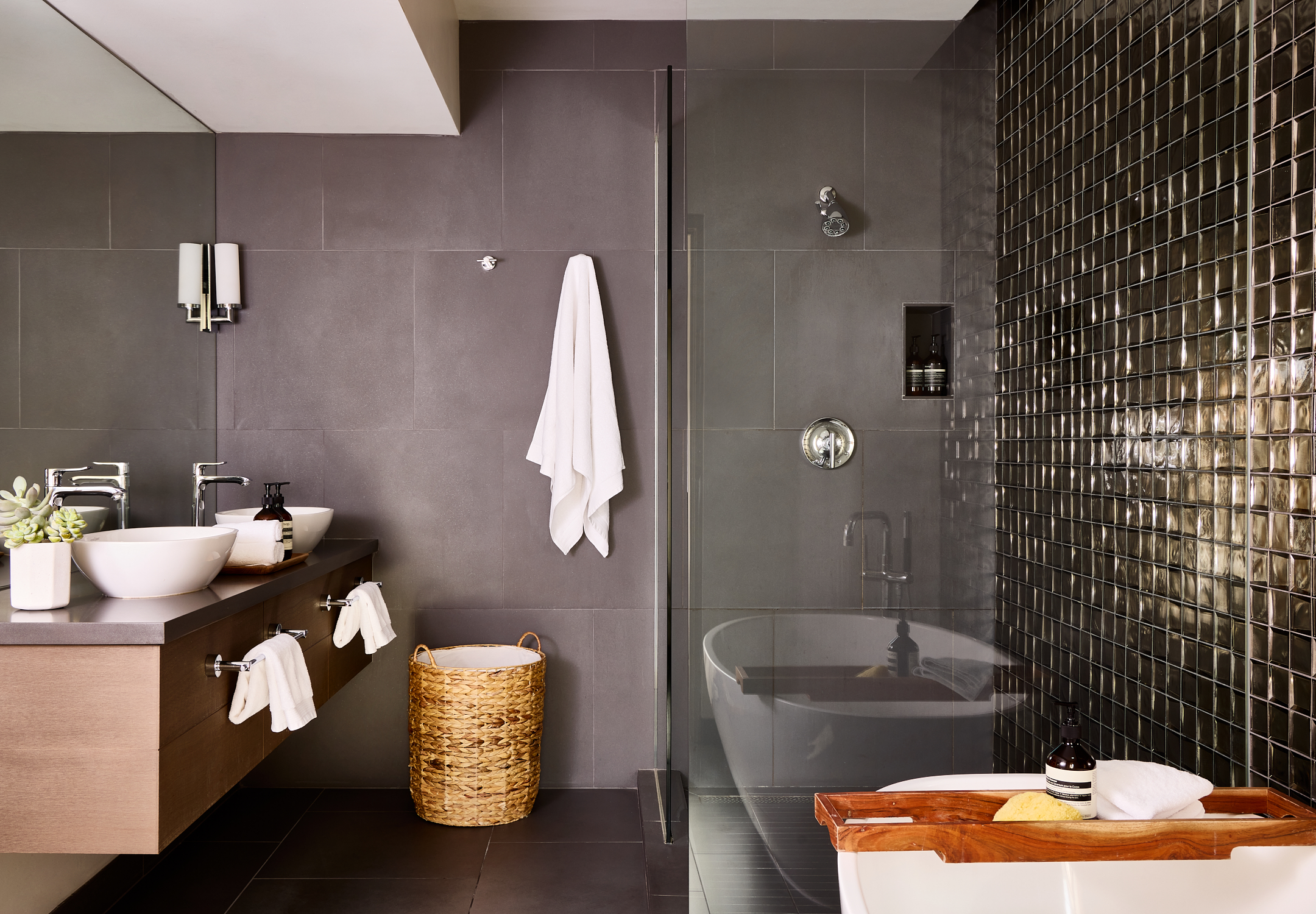 Metallic tiled bathroom with soaking tub, walk-in shower, two sinks and vanity.