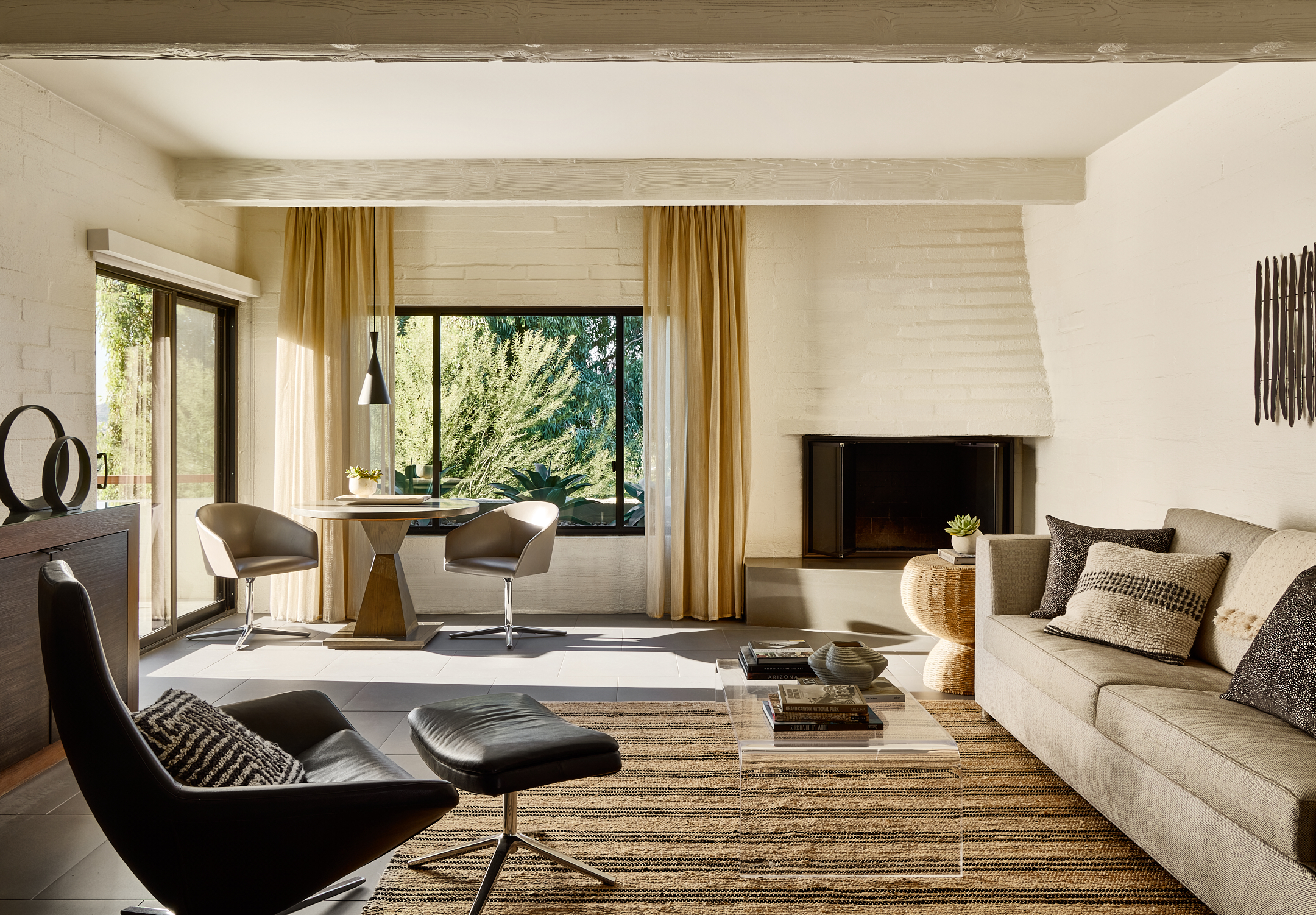 Suite living room with couch, seating area, throw rug and gas fireplace.