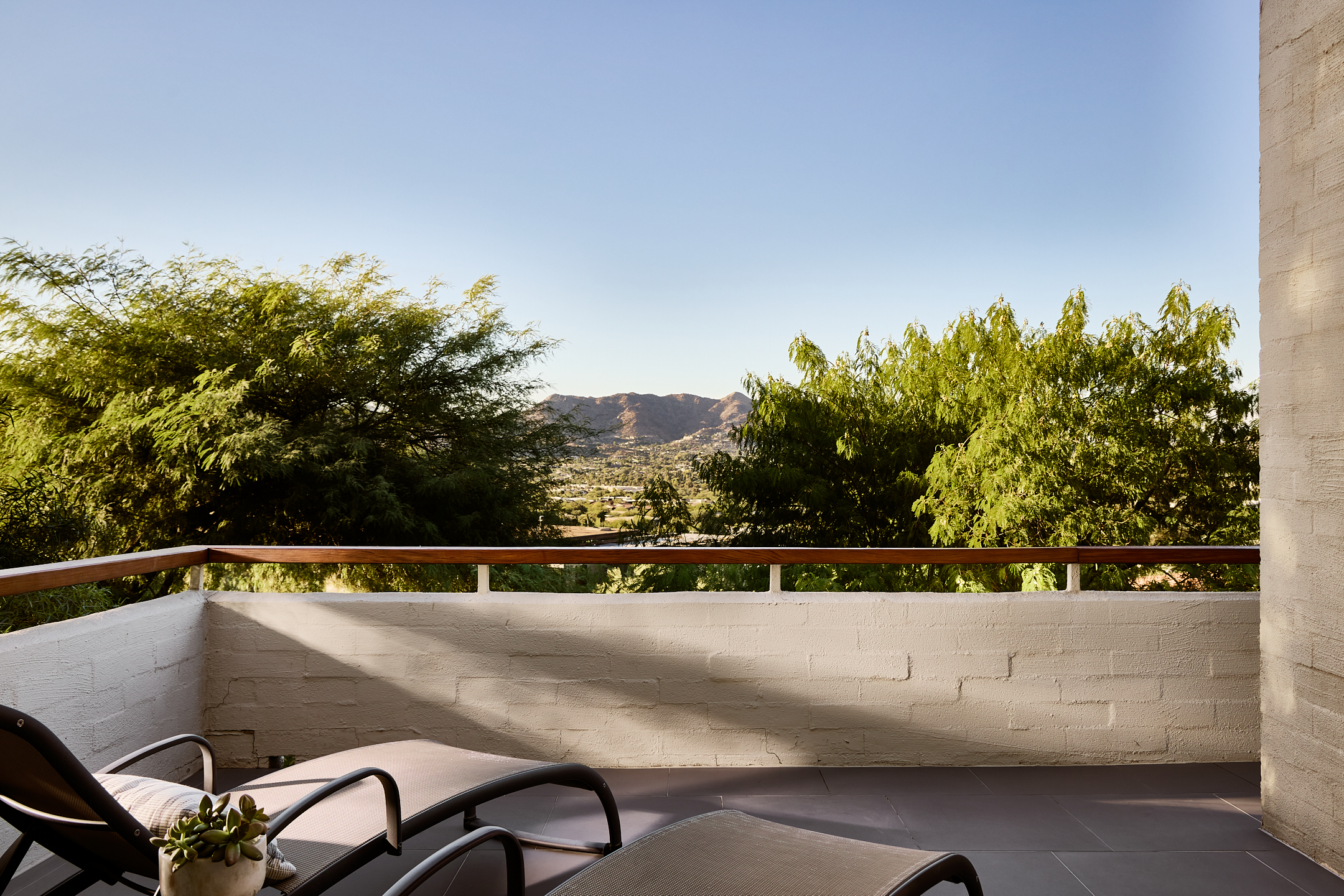 Outdoor wrap-around patio with two lounge chairs.