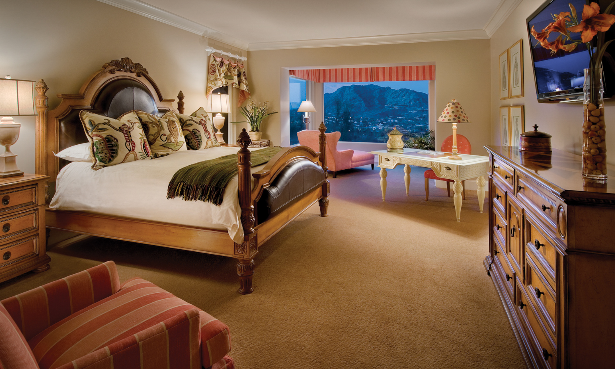 Bedroom with king bed, dresser, reading chair, writing desk and sitting area with valley views.