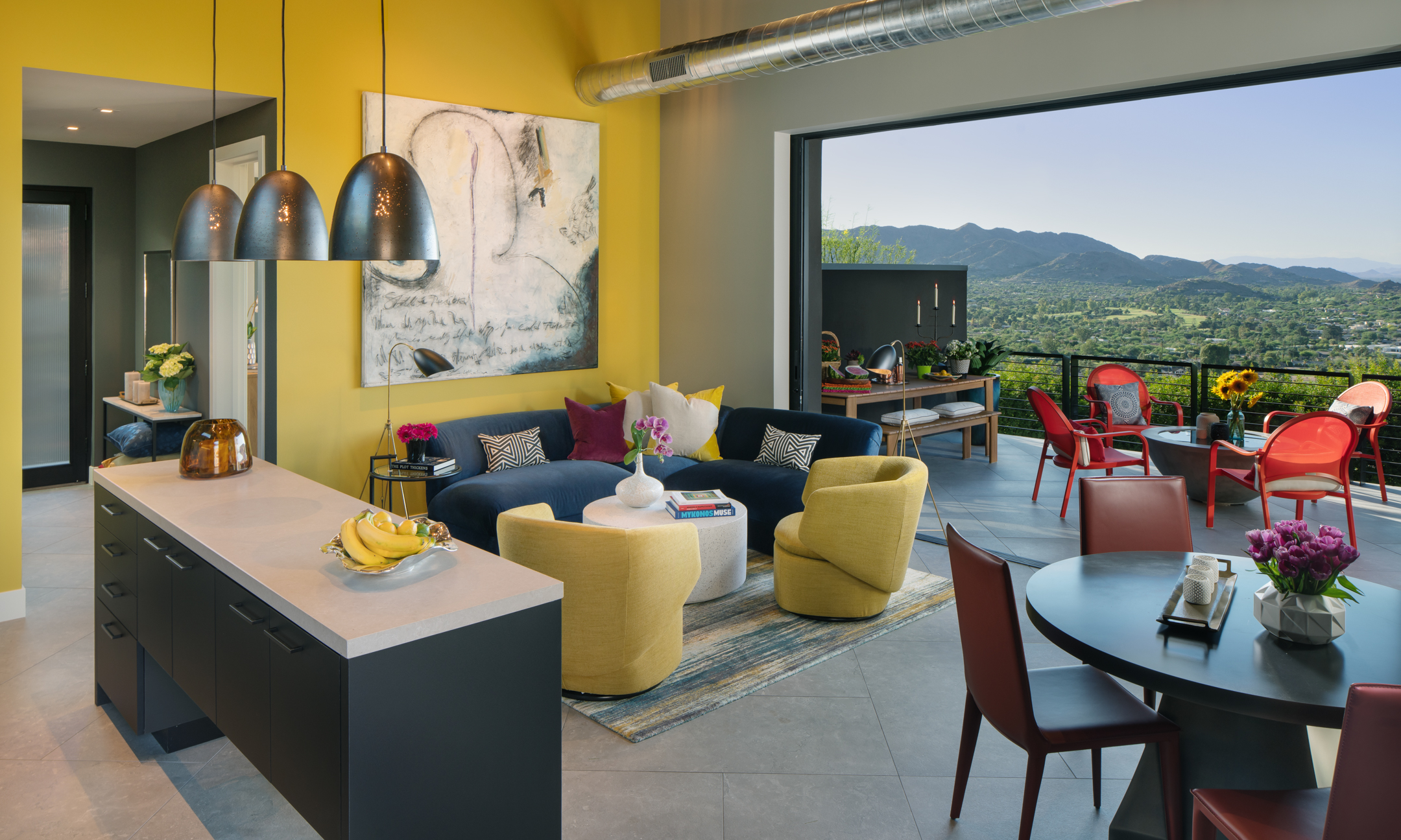 Living room with seating area and connecting kitchen with balcony and table set.