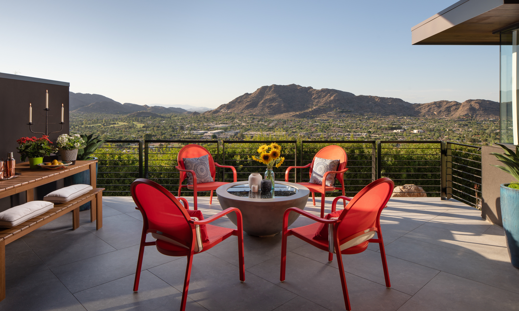 Outdoor patio with sitting area, dining table with bench and view of Mummy Mountain. 