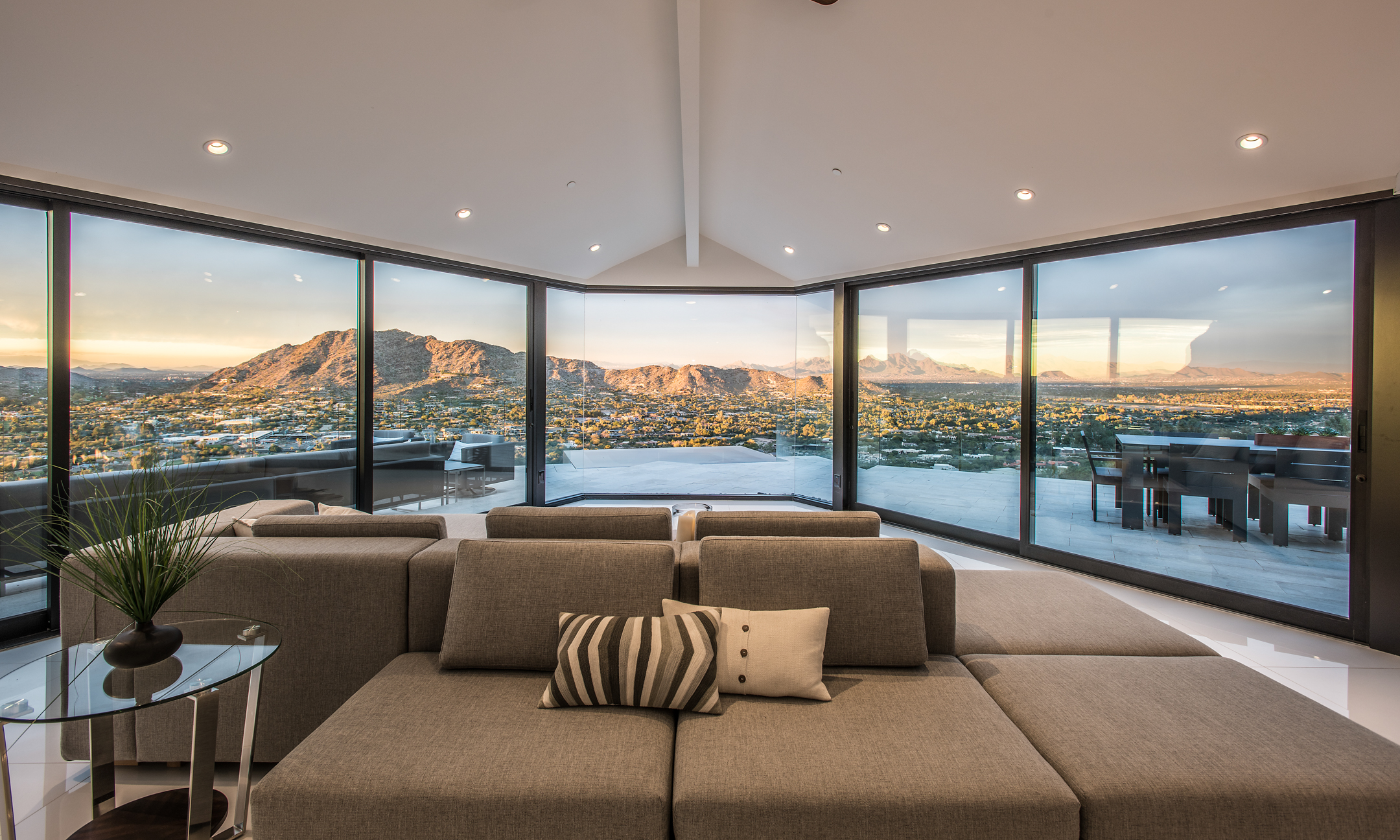 Living room with couch and floor-to-ceiling windows showing surrounding valley.