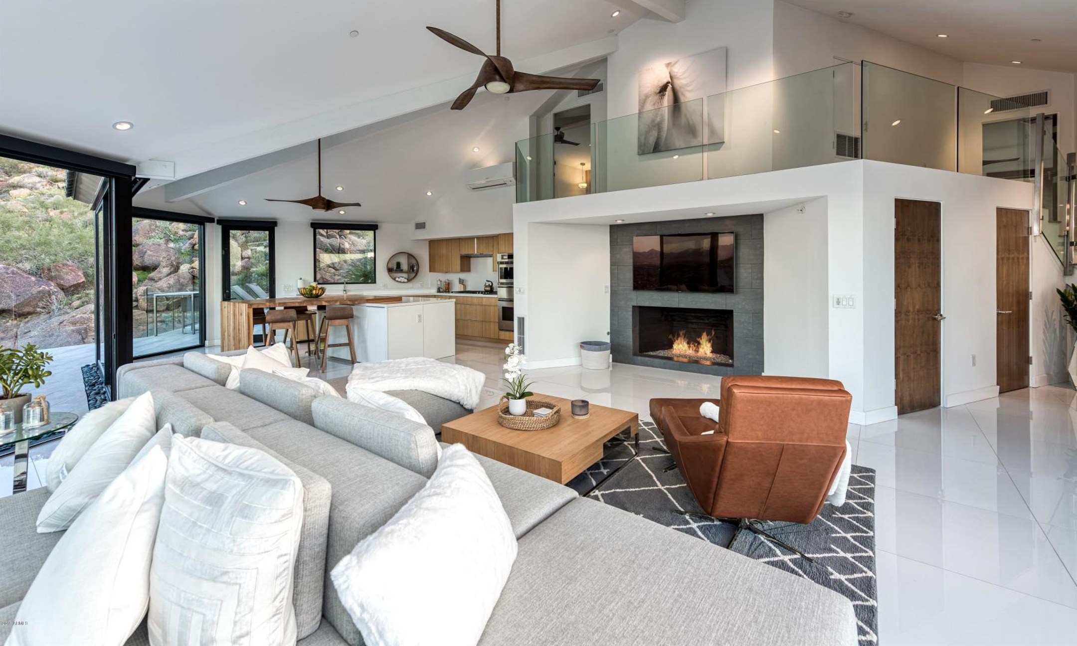 Living room with couch, chairs, gas fireplace and connecting full kitchen.