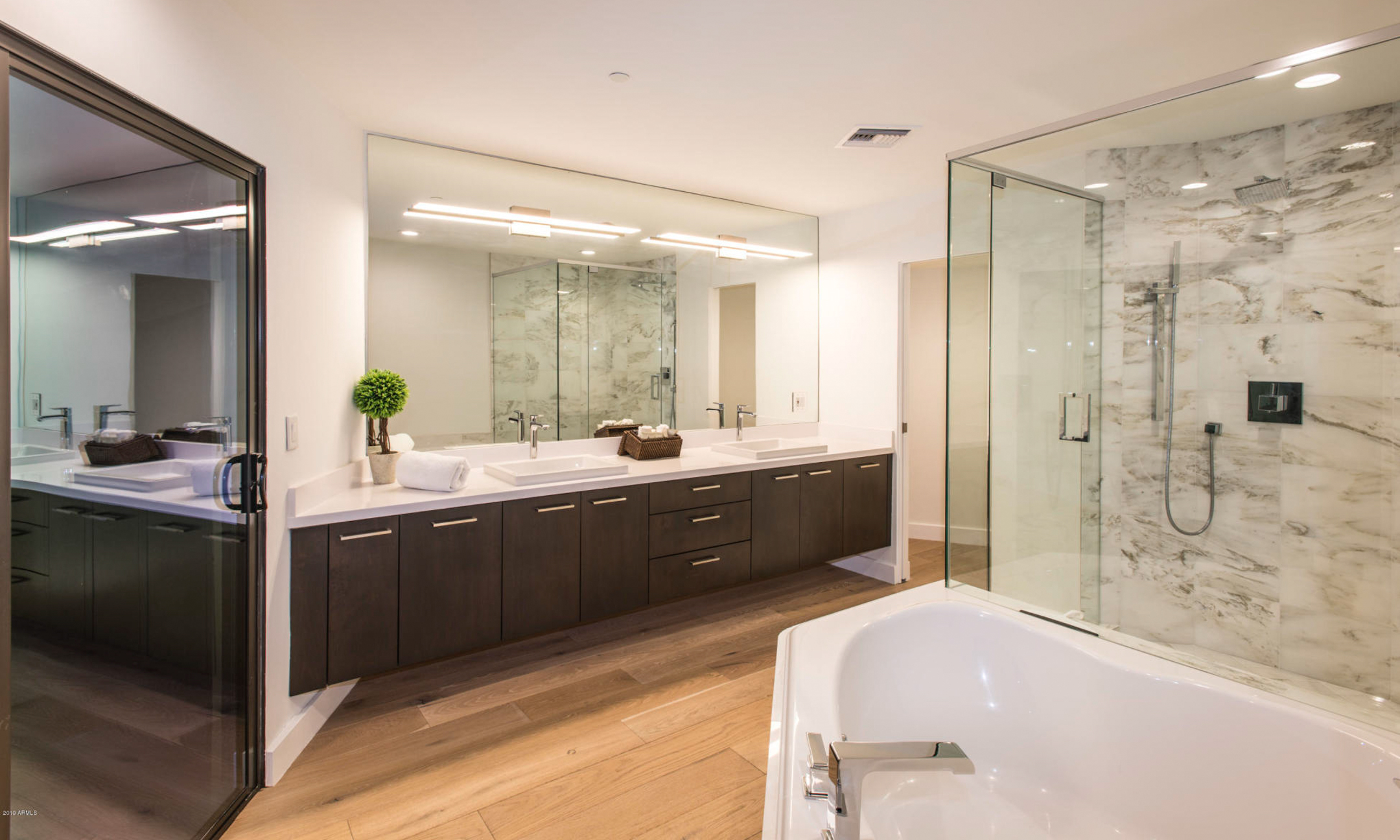 Bathroom with soaking tub, walk-in shower, two sinks and vanity.