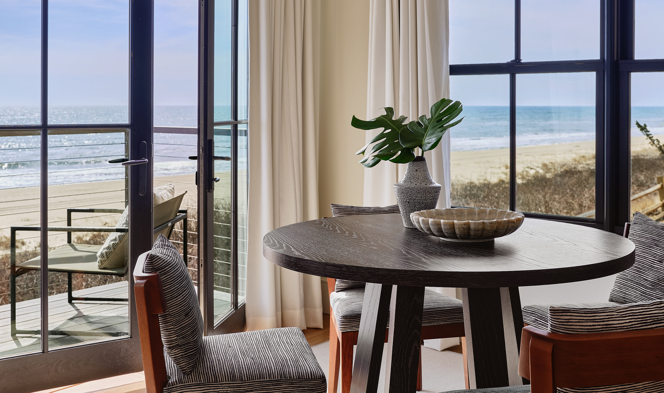 Table and chairs with beach view.
