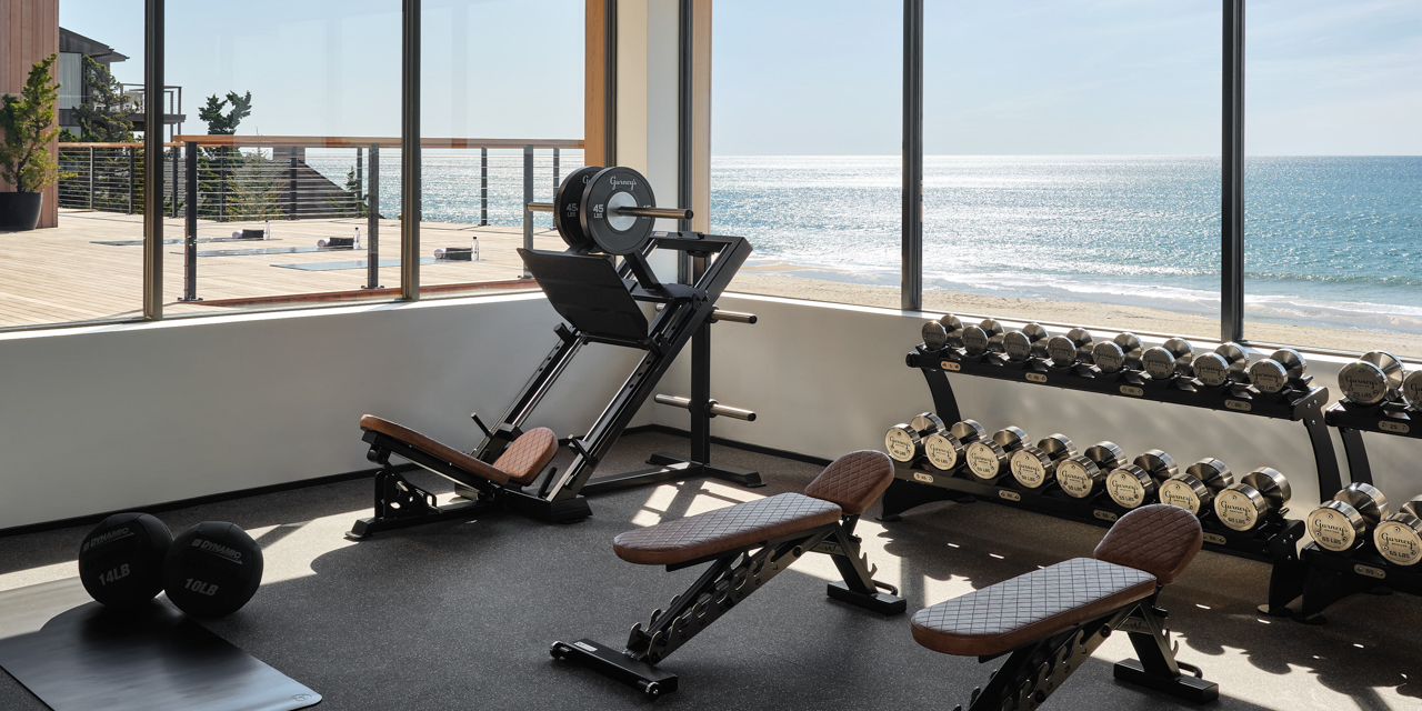 Fitness center with freights, benches, leg press and ocean view.