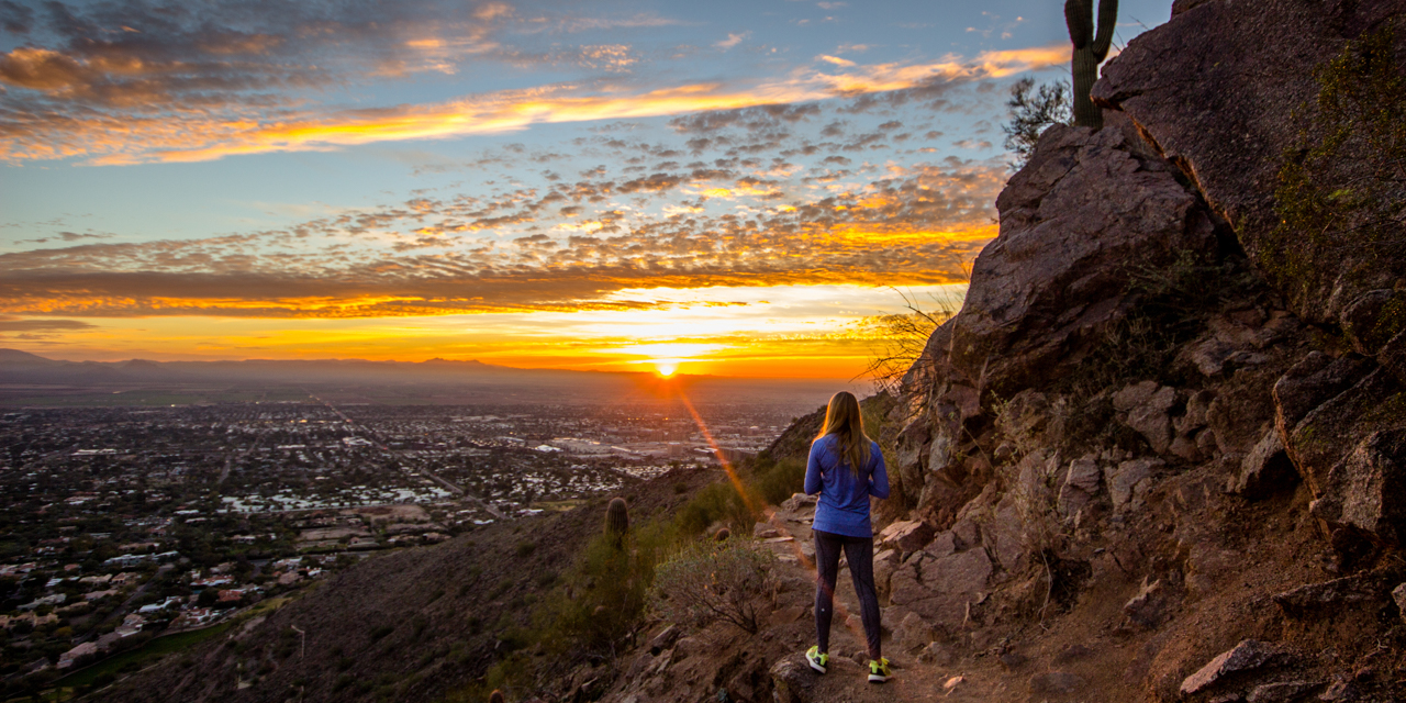 Woman watching sunset from Camelback Mountain.