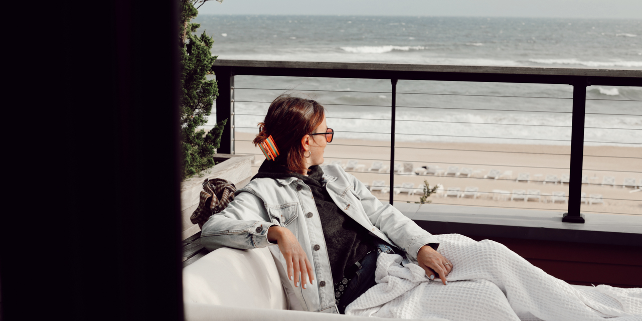 Woman watching the waves from her room's patio.