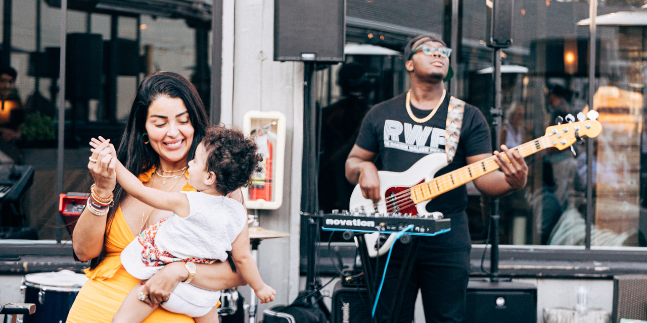 Woman dancing with small child to live music in Montauk.