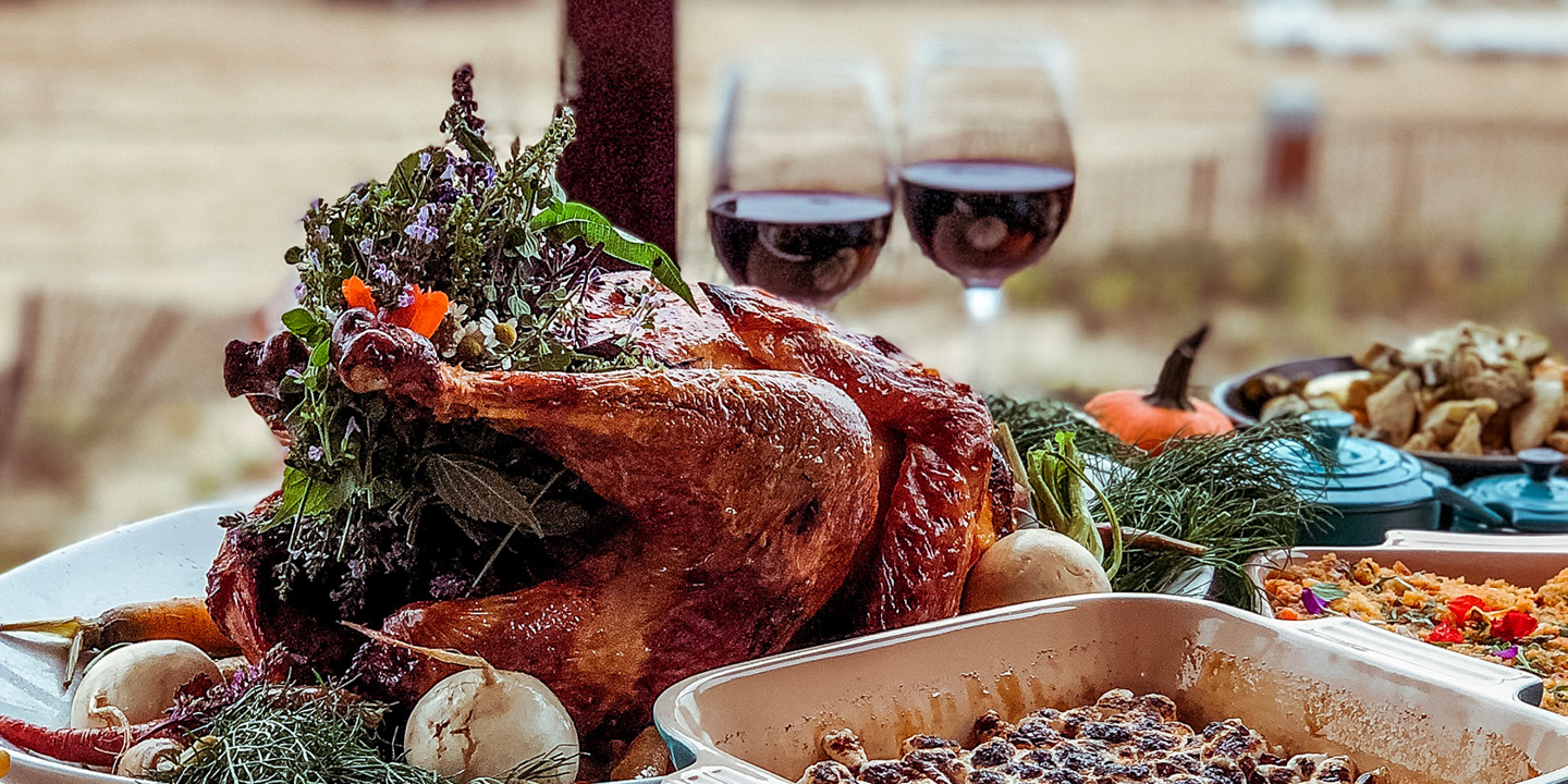 Thanksgiving dinner displayed on table with two wine glasses.