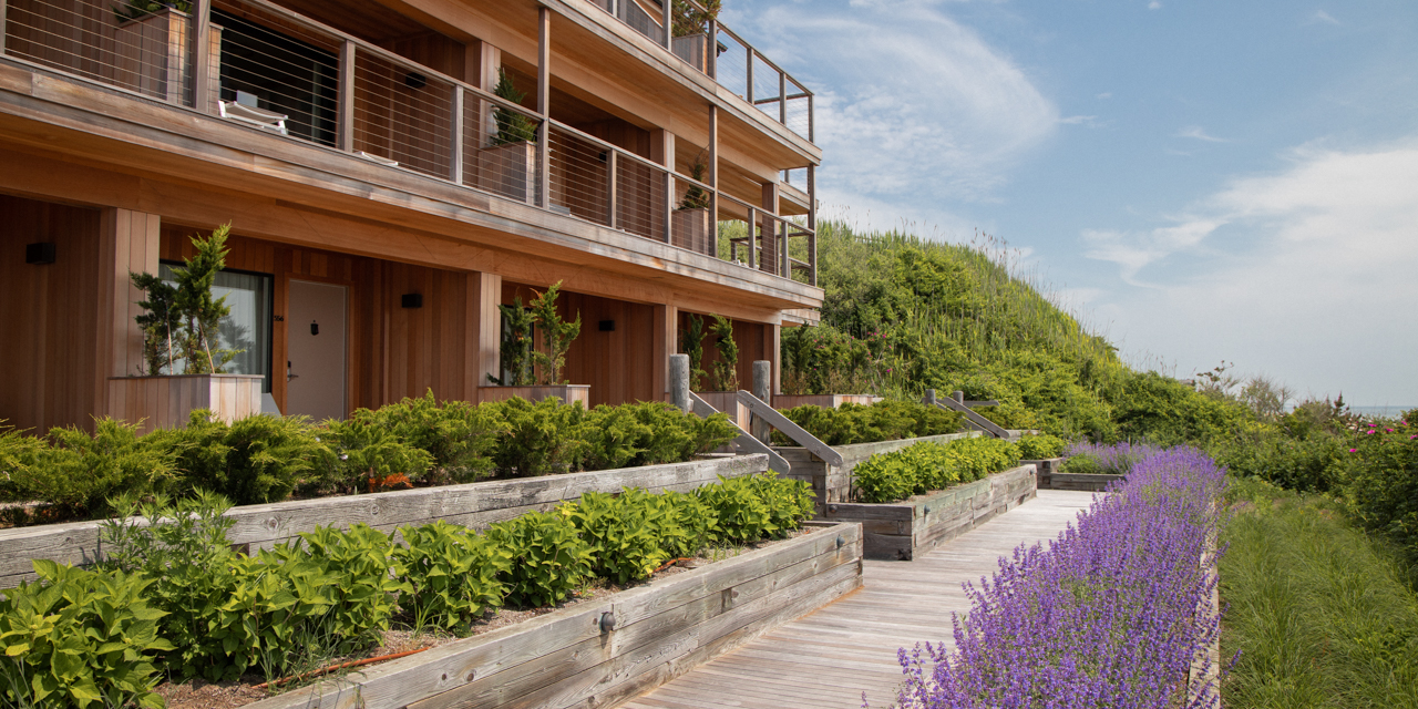 View of Gurney's Montauk wooden beach pathway in front of rooms with wooden finished patios.