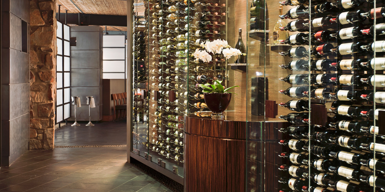 Elements wine wall with wine bottles and floral decor.