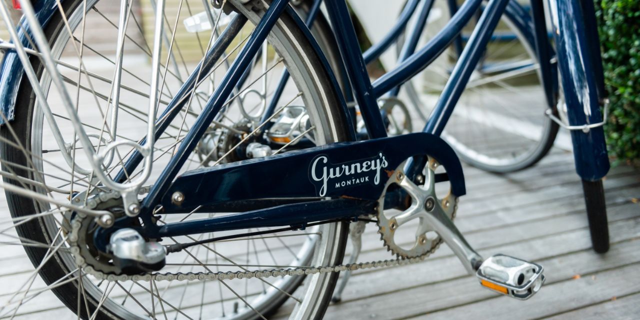 A close up of a navy blue beach cruiser bike with the Gurney's Montauk logo