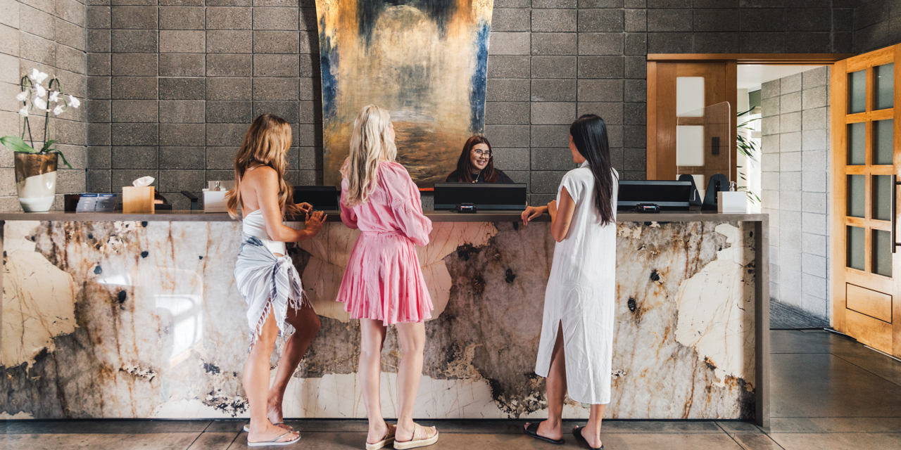 Three girlfriends checking in at Sanctuary Spa's front desk.