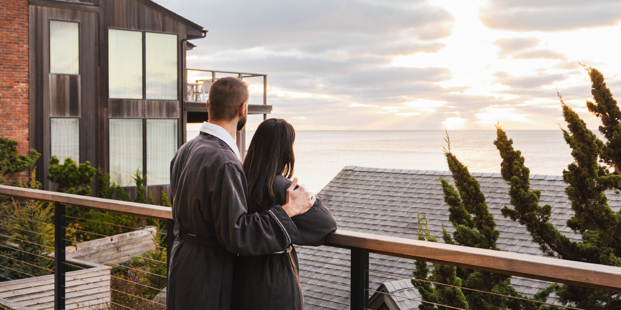 A man and a woman in robes overlook the ocean at Gurney's Montauk Resort