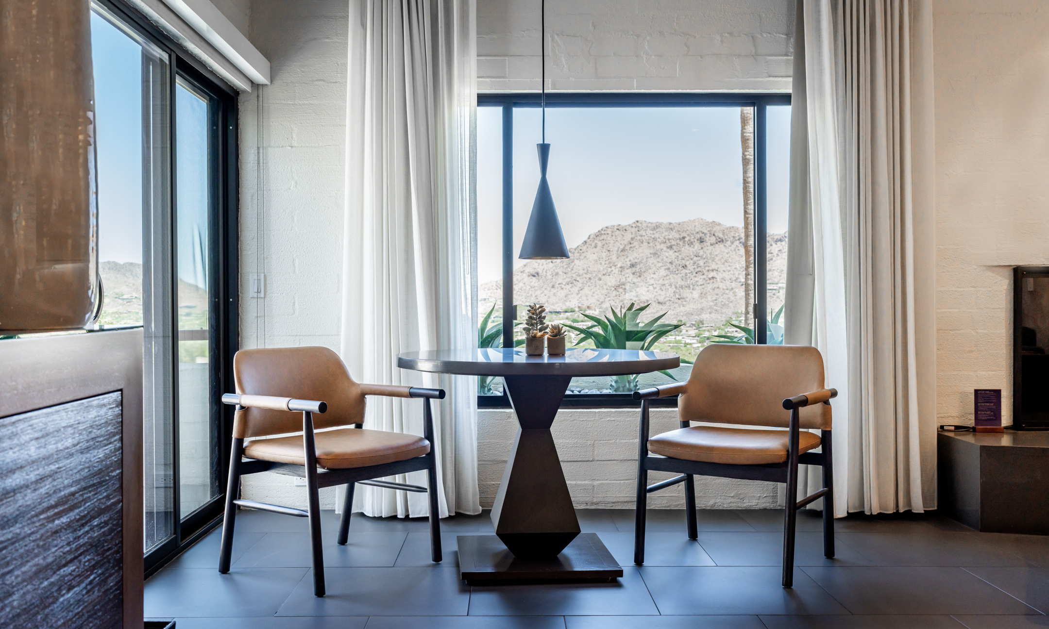 Suite sitting area with table and chairs overlooking valley views.