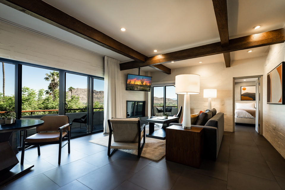 Camelback Suite with living room seating area, comfortable couch, table and chairs, fireplace and television, separate bedroom and wrap around patio.