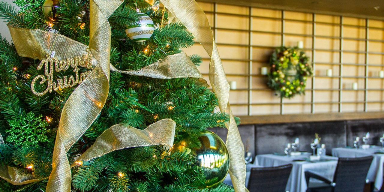 Close-up of Christmas Tree decorated with lights, bulbs and gold tensile in elements. 