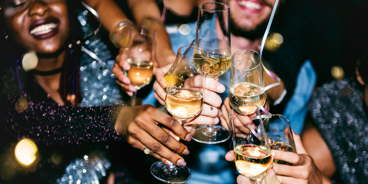 A group of friends brings their Champagne glasses together in a cheers