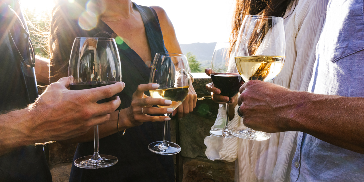 Two couples enjoying glasses of wine on elements Sunset Patio.