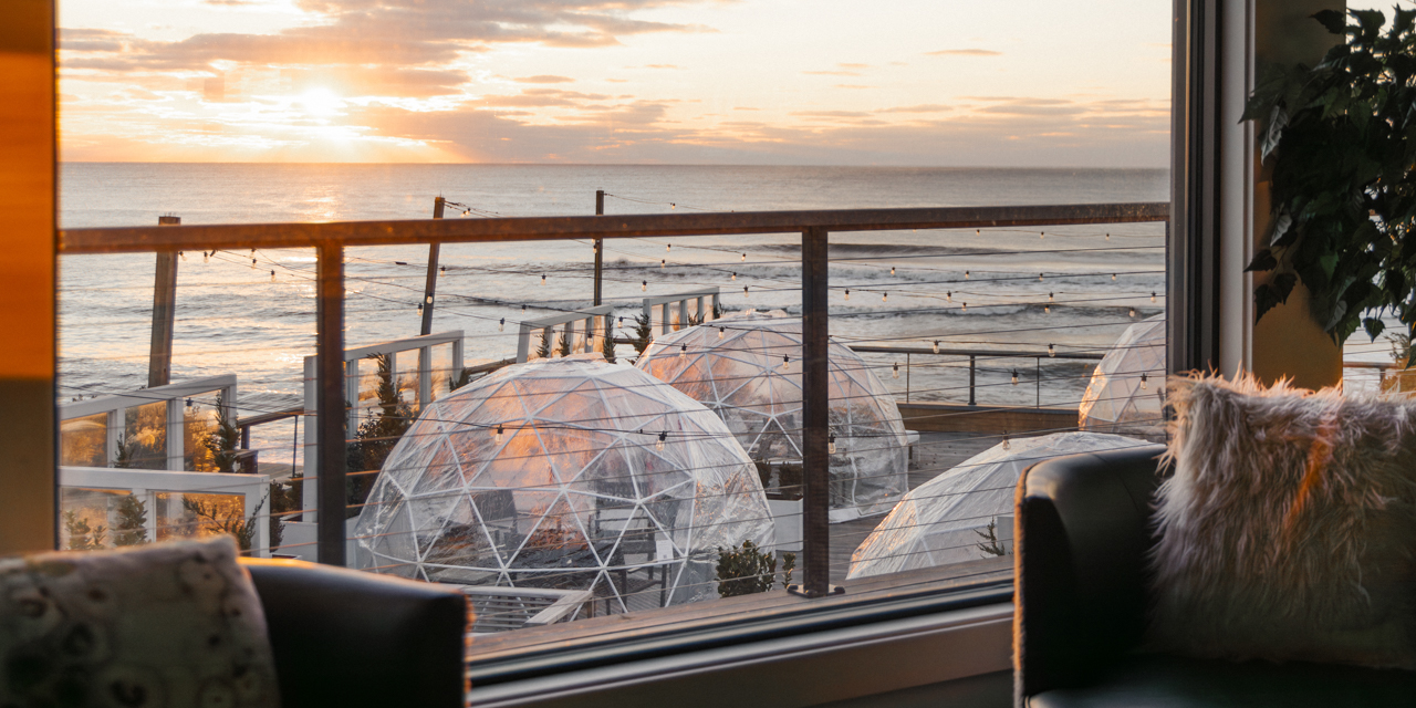 View of Igloos at Gurney's Montauk with scenic ocean sunset in background.