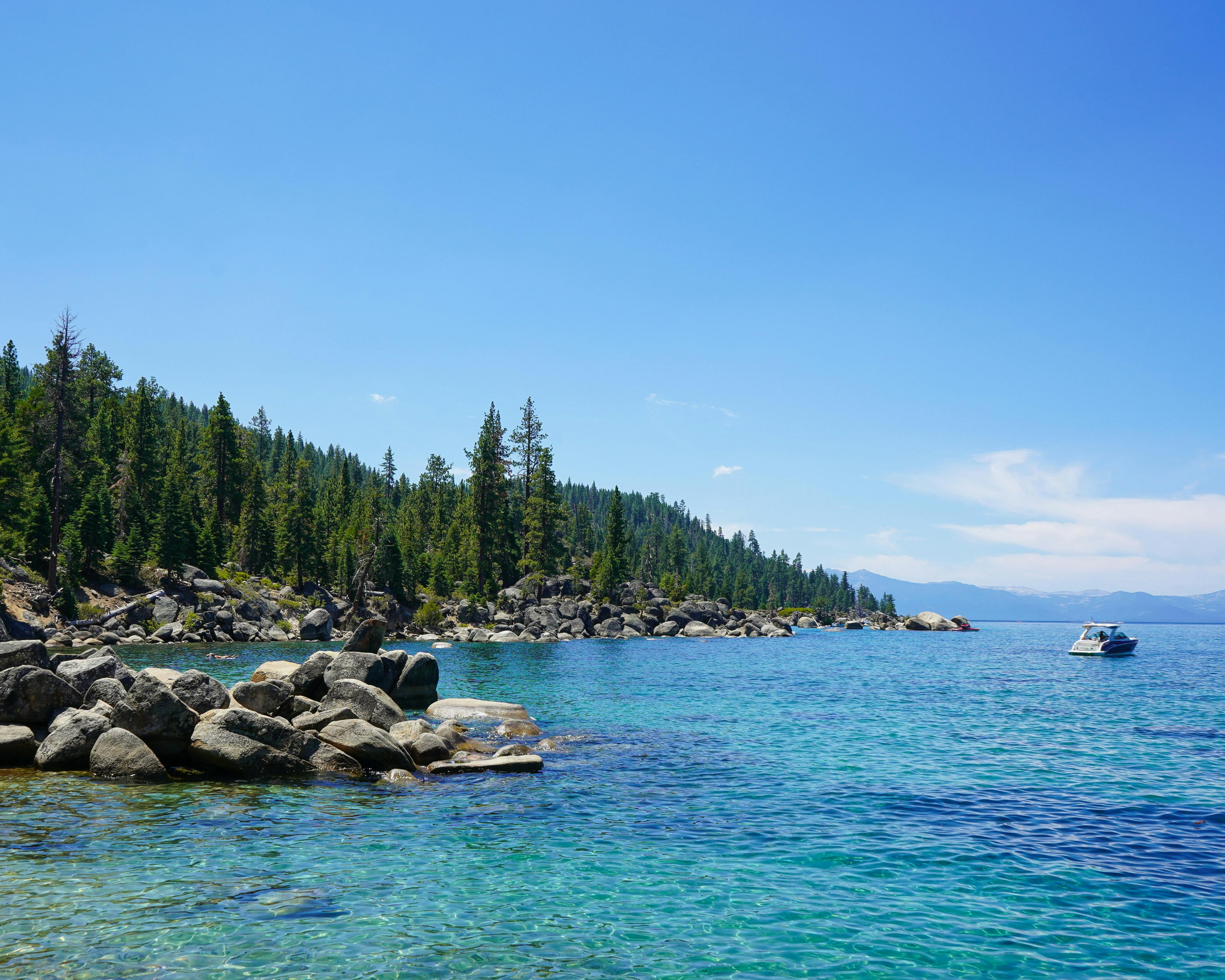 Image of Lake and side of land with rocks and trees. 
