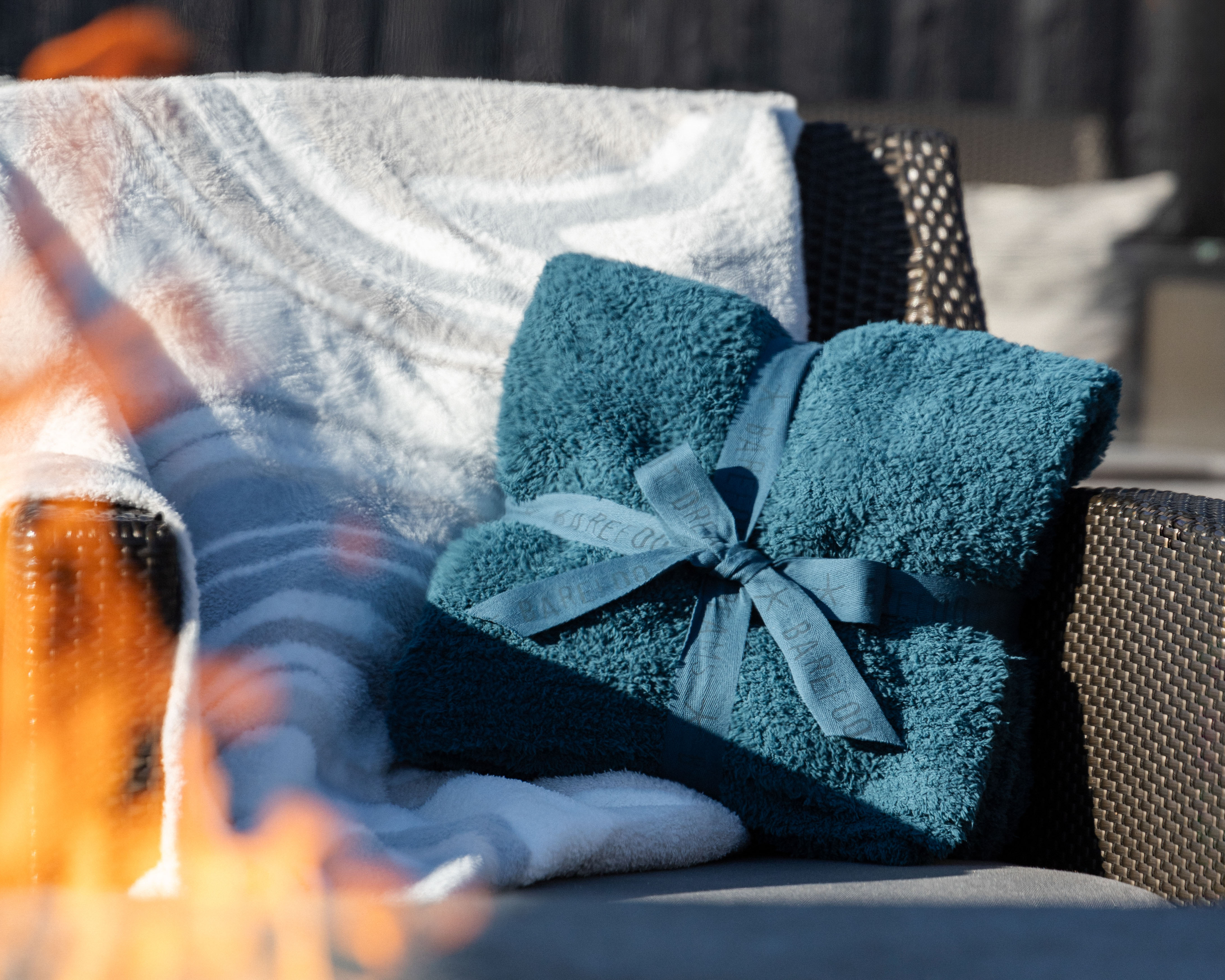 Chair in front of fire with blue Barefoot Dreams blanket.