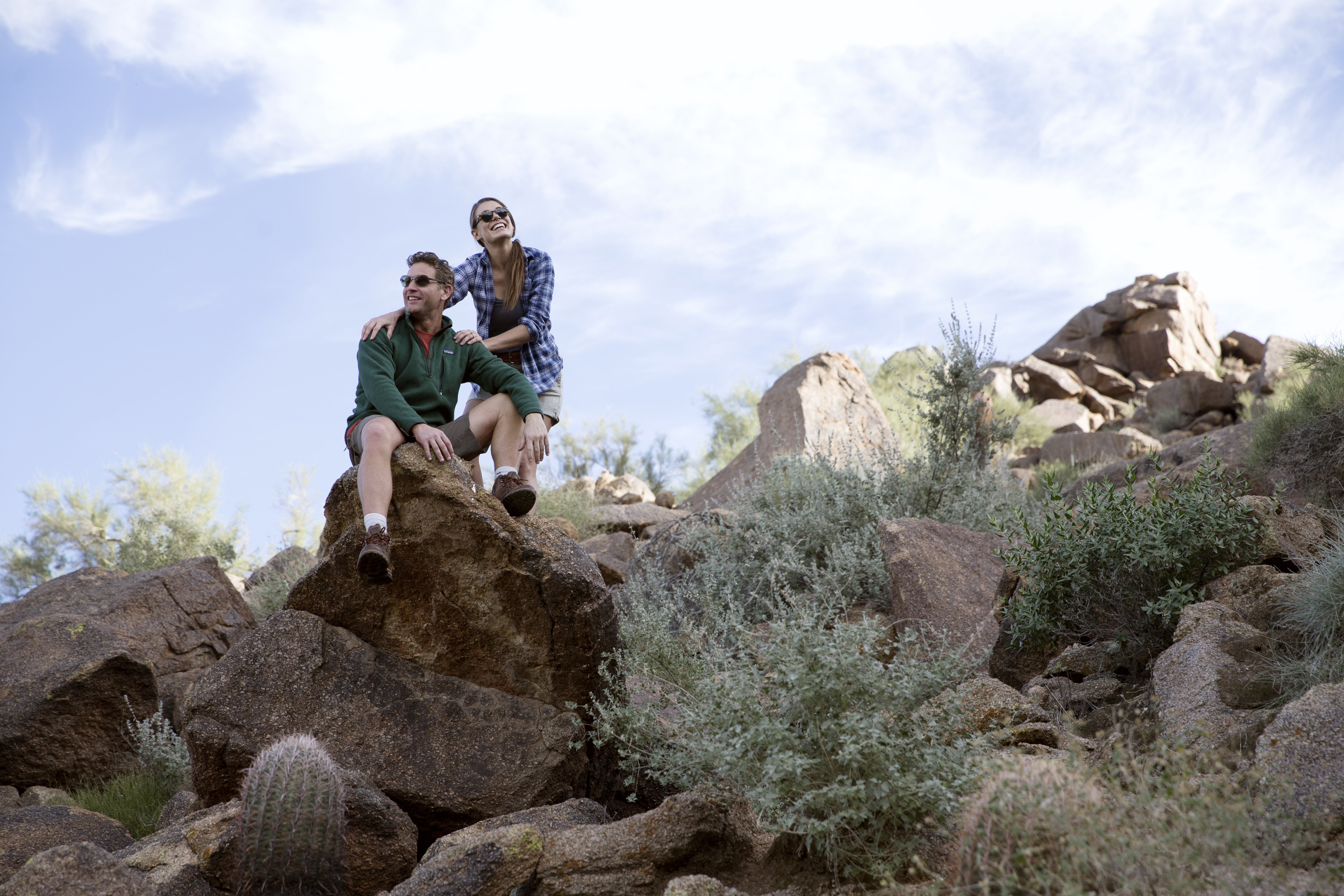 A couple takes a rest while hiking over boulders