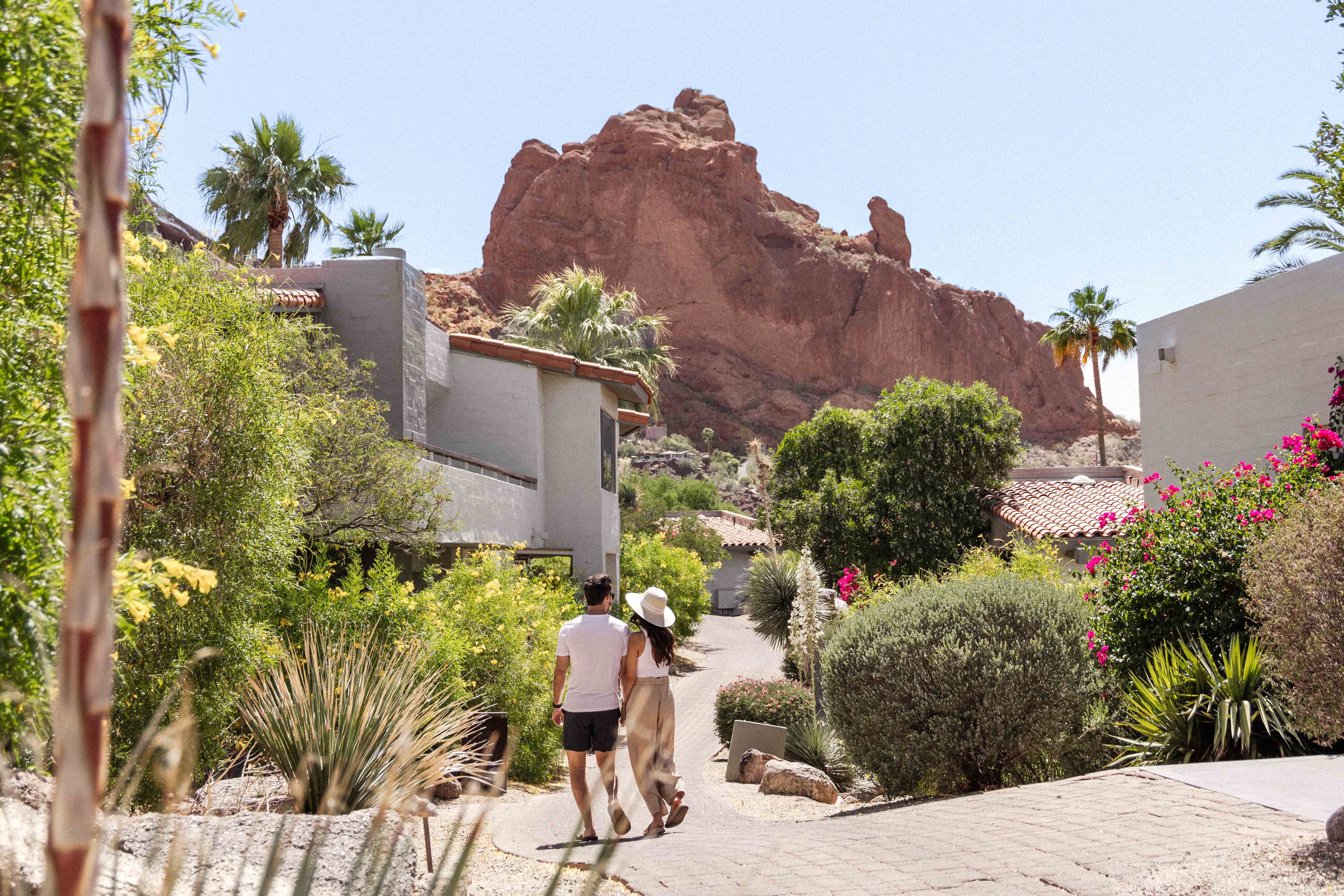 Couple walking through lush desert grounds surrounding Sanctuary's Mountain Casitas and Suites.