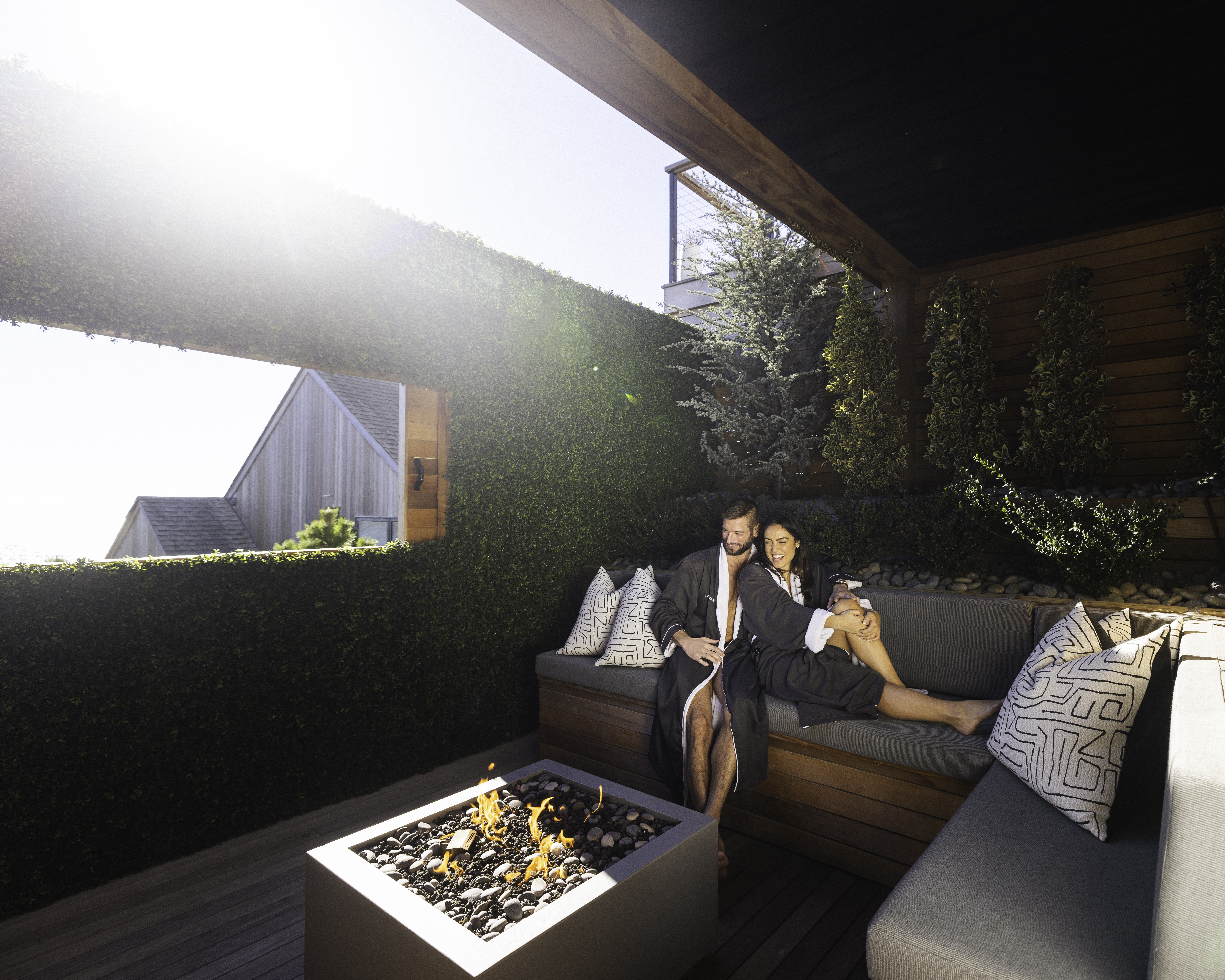 Couple in robes cuddling in front of firepit in private treatment suite at Gurney's Seawater Spa.