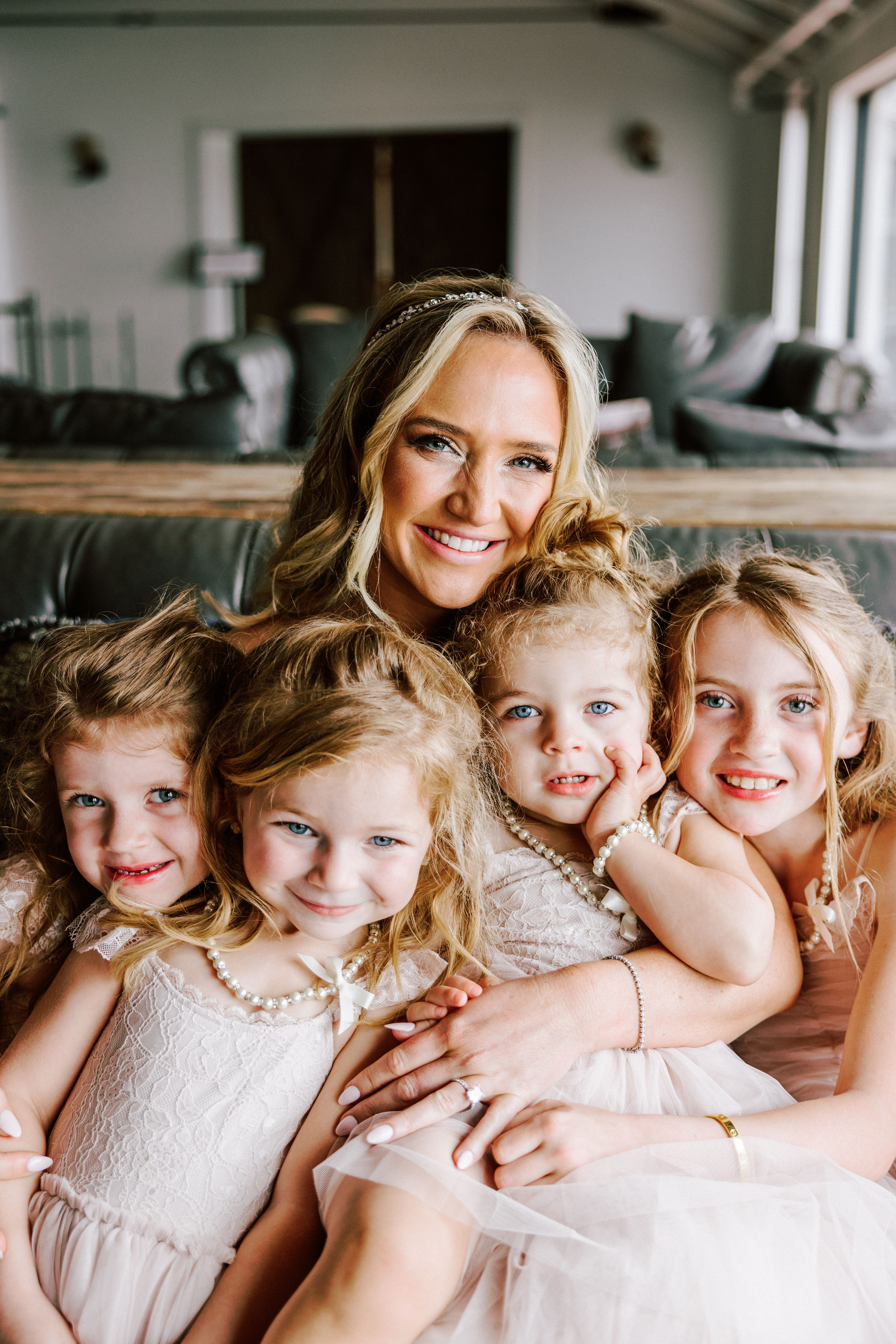 Bride posing sharing an intimate moment with several little girls in dresses.