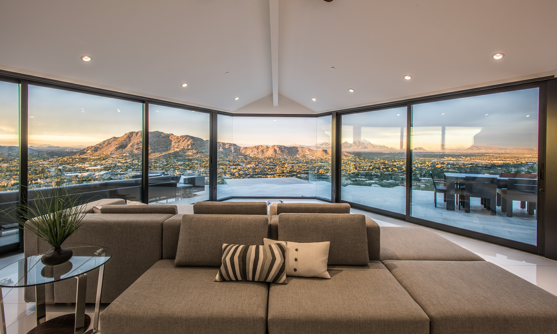 View from living room couch showing floor-to-ceiling windows, showcasing wrap-around patio and spectacular valley views.