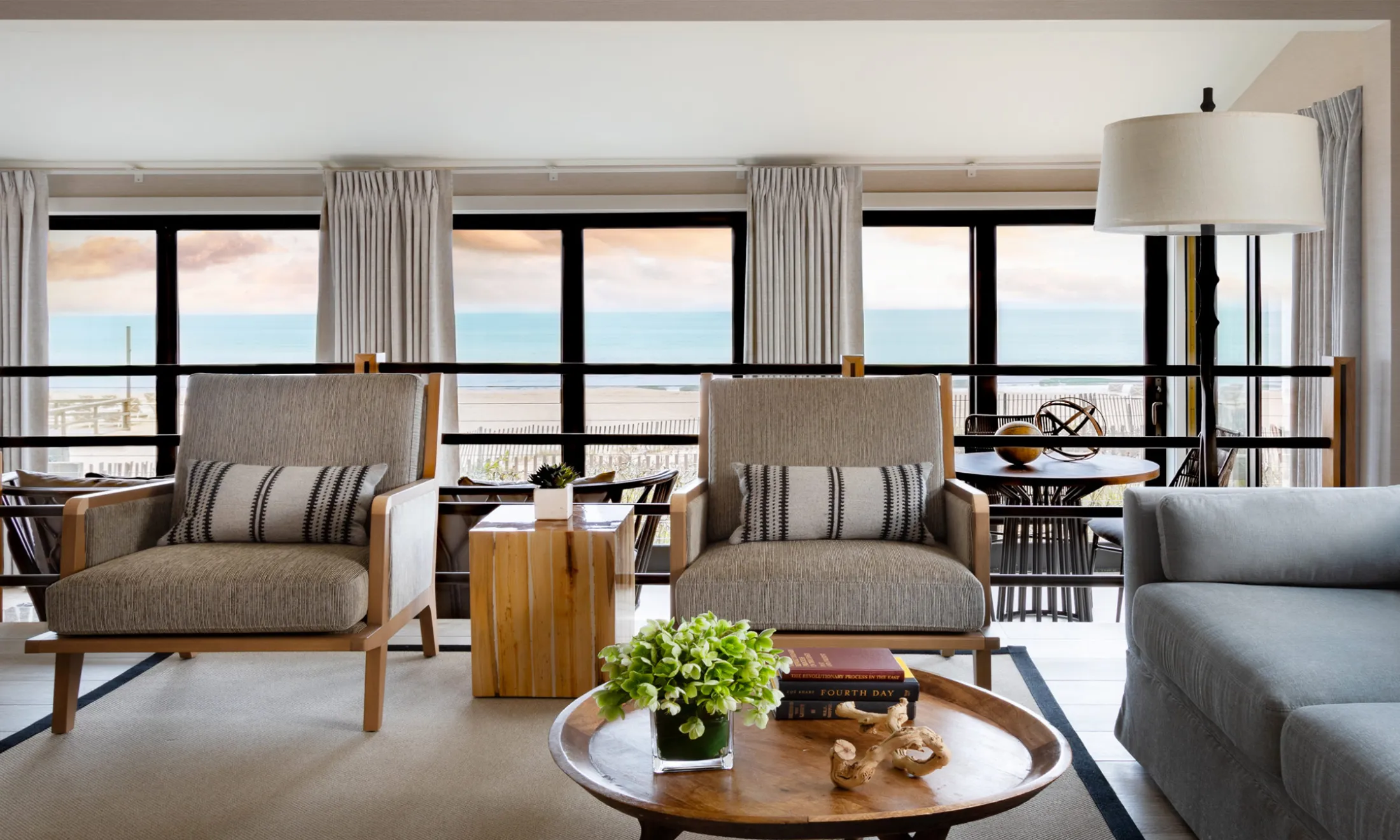 A wide view of a furnished living room with a view of the ocean