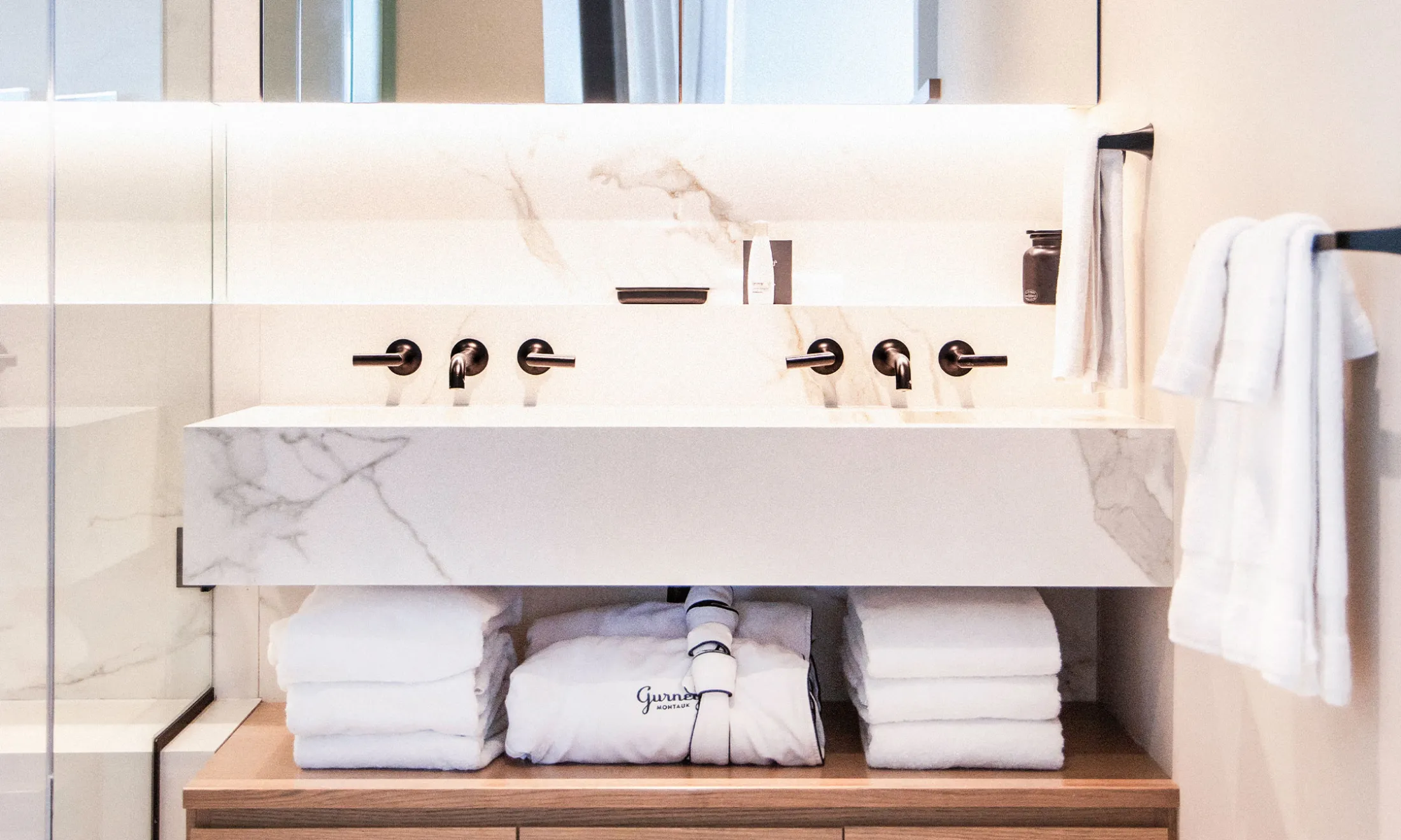 A modern bathroom sink with a marble countertop and double faucet