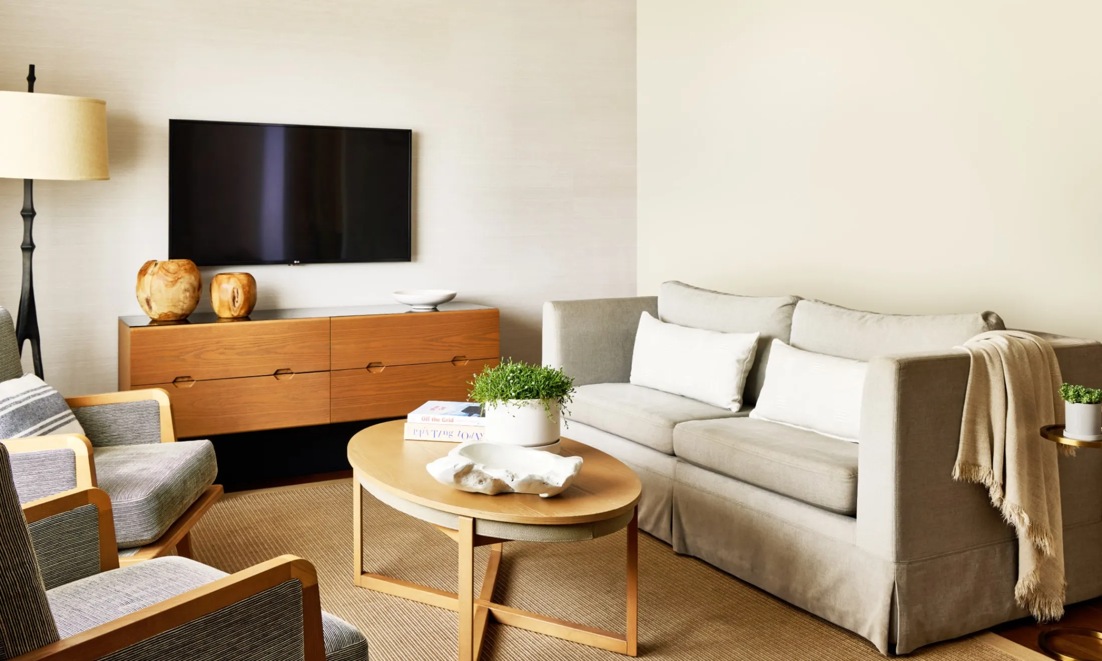 A living room with a sofa, coffee table, TV, and chair.