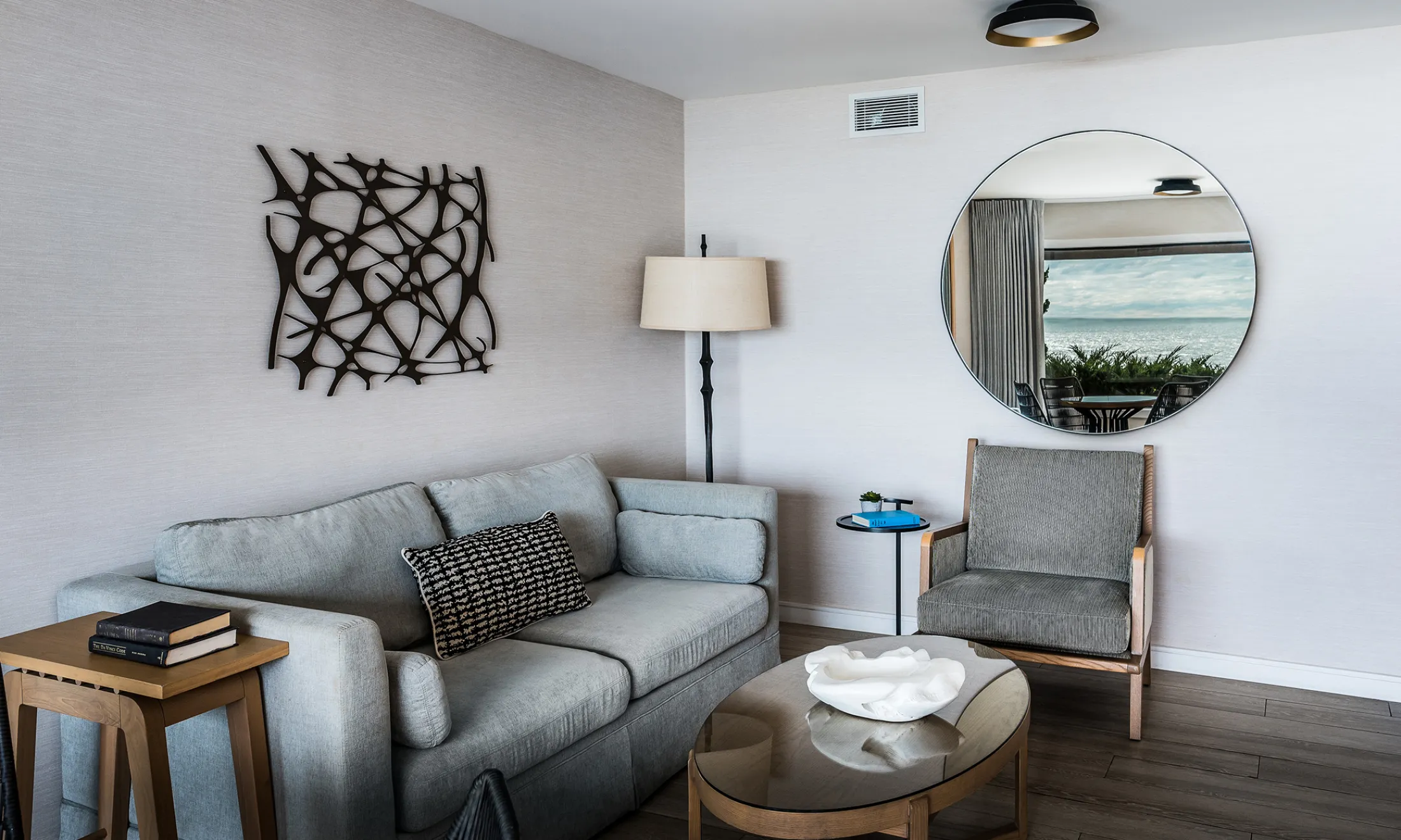 A sitting area with a sofa, chair, coffee table, and lamp.