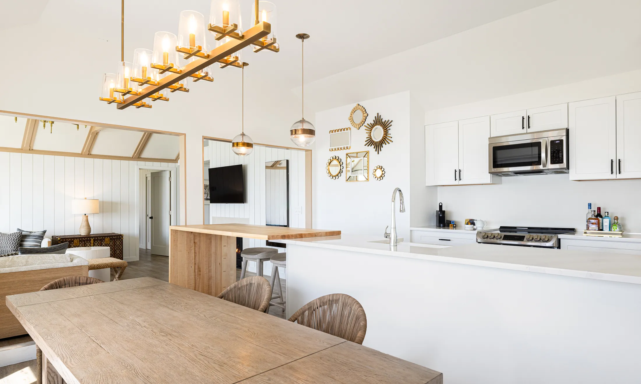A wide view of a modern kitchen and living area with a dining table.