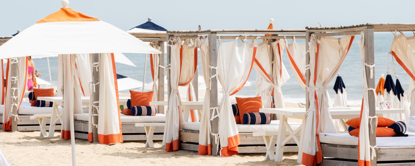 A row of beach cabanas line the sand at Gurney's Montauk Beach Club