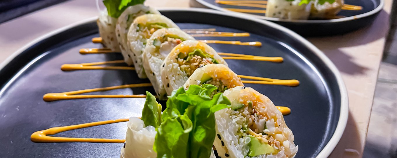 Two plates featuring colorful sushi rolls
