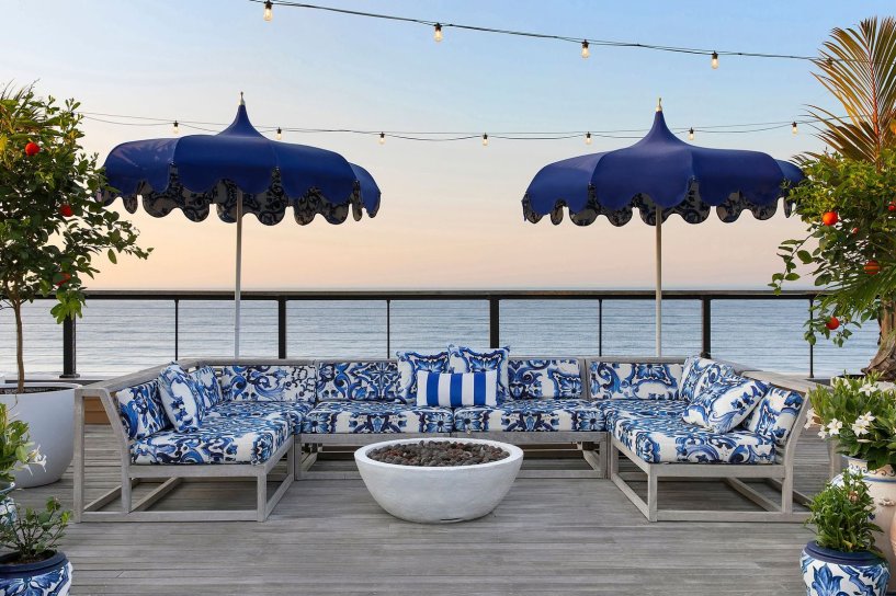 Blue and White day chairs and umbrellas in front of sunset 