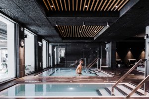 Man in black swim trunks getting into one of the bathhouse saltwater pools.